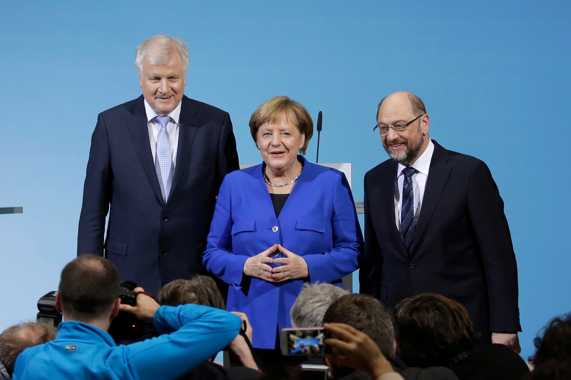German Chancellor Angela Merkel is flanked by Bavarian governor Horst Seehofer, left, and Social Democratic Party Chairman Martin Schulz as they pose for a photo after the exploratory talks between Merkel's Christian Democratic block and the Social Democrats on forming a new German government in Berlin, Germany, Friday, Jan. 12, 2018. (AP Photo/Markus Schreiber) Germany Politics