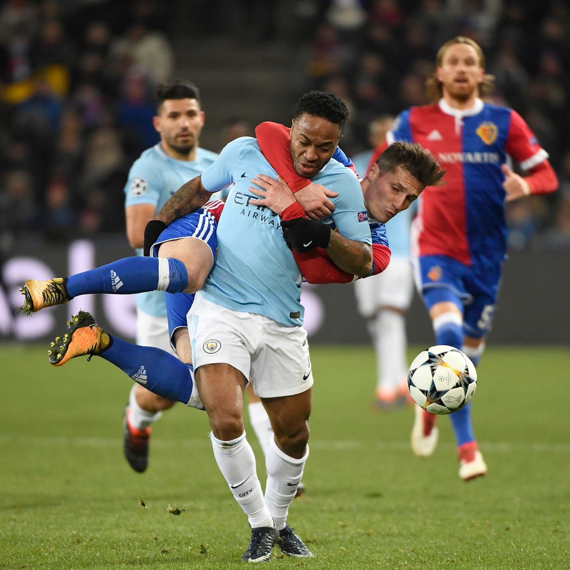 Basel's Taulant Xhaka, behind, clings to Manchester City's Raheem Sterling, front, and will get the yellow card for this action, during the UEFA Champions League round of sixteen first leg soccer match between Switzerland's FC Basel 1893 and England's Manchester City FC in the St. Jakob-Park stadium in Basel, Switzerland, on Tuesday, February 13, 2018. (KEYSTONE/Georgios Kefalas) SWITZERLAND SOCCER CHAMPIONS LEAGUE