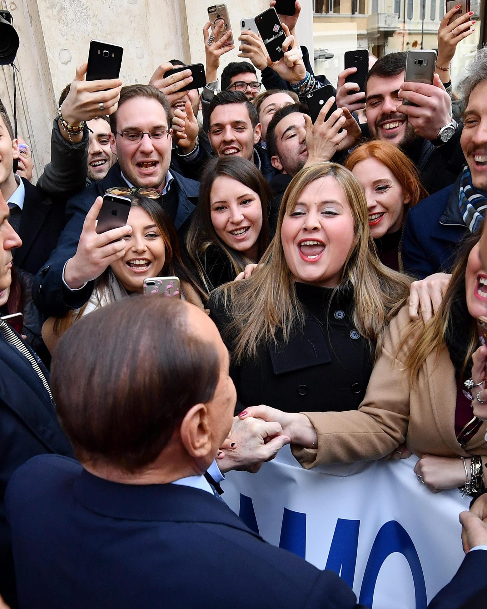 Former Italian Premier Silvio Berlusconi is cheered by followers prior to a meeting with European PeopleÄôs Party President Manfred Weber, in Rome Wednesday, Feb. 21, 2018. Berlusconi arrived on foot at a piazza in Rome where the meeting was to be held, greeted by hundreds of supporters chanting ÄúSilvio, Silvio, SilvioÄù.  He paused and explained to his fans that they need to make an X on the Forza Italia symbol on the ballot. (Ettore Ferrari/ANSA via AP) Italy Berlusconi