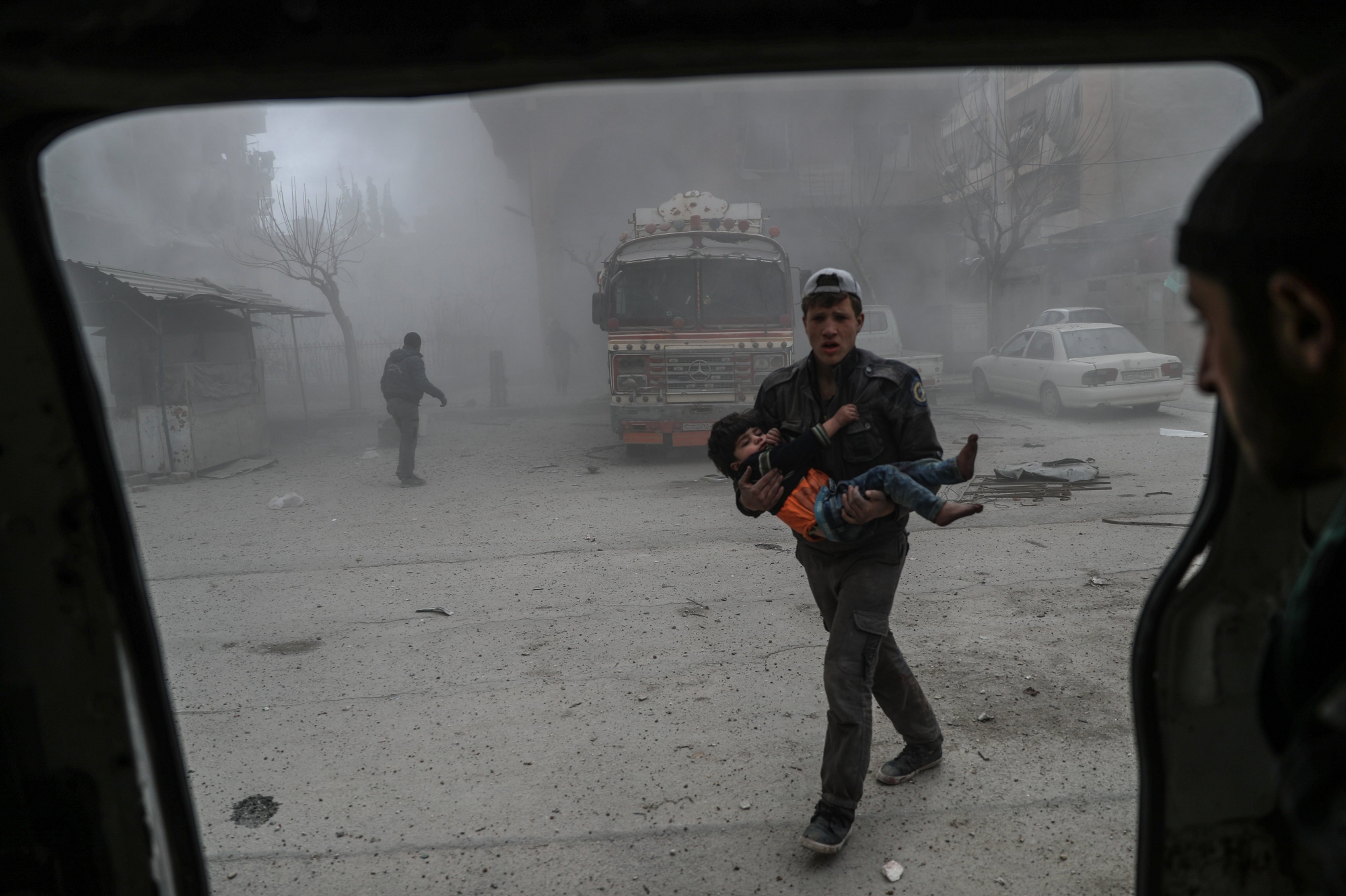 epa06555674 White helmet volunteer carries an injured boy to an ambulance after bombing, in the rebel-held Douma, Eastern Ghouta, Syria, 22 February 2018. More than 42 people got killed in Douma after several airstrikes and shelling by forces allegedly loyal to the Syrian Government. At least 80 people got killed in Eastern Ghouta on the same day, according to local sources.  EPA/MOHAMMED BADRA SYRIA CONFLICT DOUMA EASTERN GHOUTA