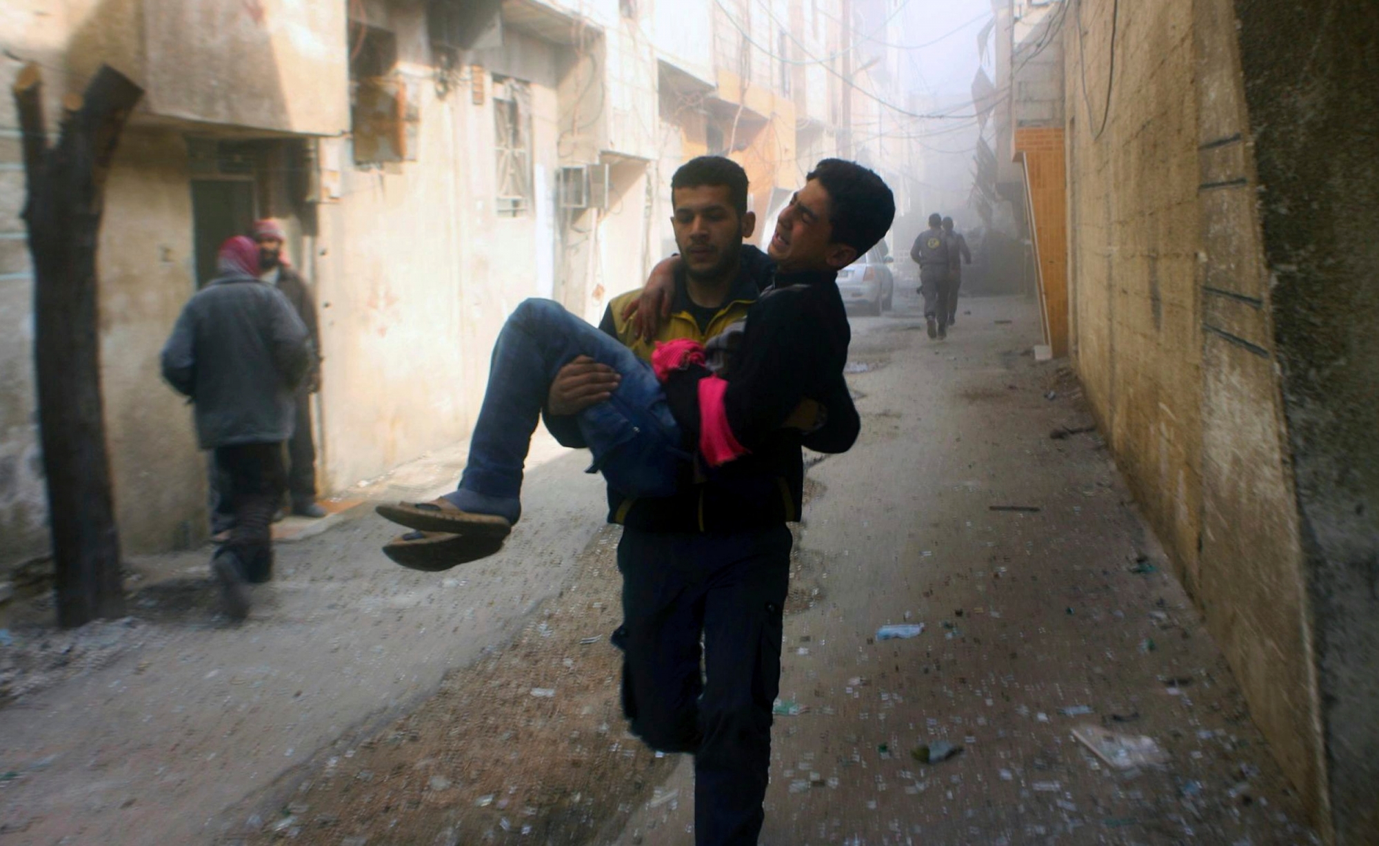 This photo released on Saturday, Feb 24, 2018 by the Syrian Civil Defense group known as the White Helmets, shows members of the Syrian Civil Defense group carrying a young man who was wounded during airstrikes and shelling by Syrian government forces, in Ghouta, a suburb of Damascus, Syria. A new wave of airstrikes and shelling on eastern suburbs of the Syrian capital Damascus left at least 22 people dead and more than a dozen wounded Saturday, raising the death toll of a week of bombing in the area to nearly 500, including scores of women and children. (Syrian Civil Defense White Helmets via AP) Syria