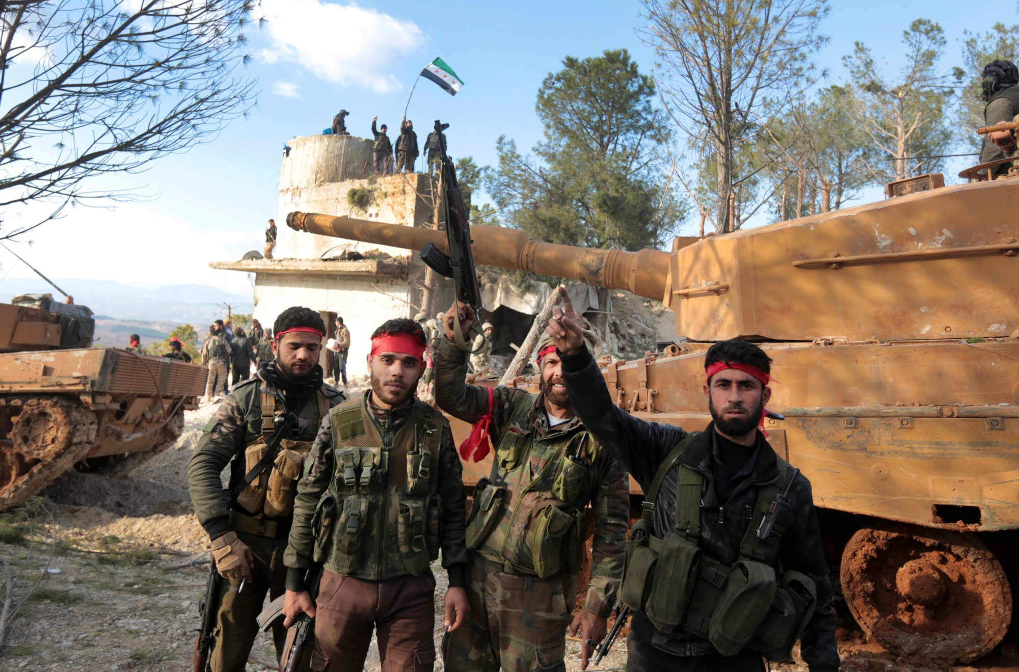 FILE -- In this January 28, 2018 file photo, Pro-Turkey Syrian fighters, centre, and Turkish troops secure the Bursayah hill, which separates the Kurdish-held enclave of Afrin from the Turkey-controlled town of Azaz, Syria. TurkeyÄôs shattering war on a Syrian Kurdish militia that is closely aligned with the United States is forcing the group to give up positions against Islamic State militants in the Syrian desert to defend against advancing Turkish troops. (AP Photo, File) Syria Kurds New Front