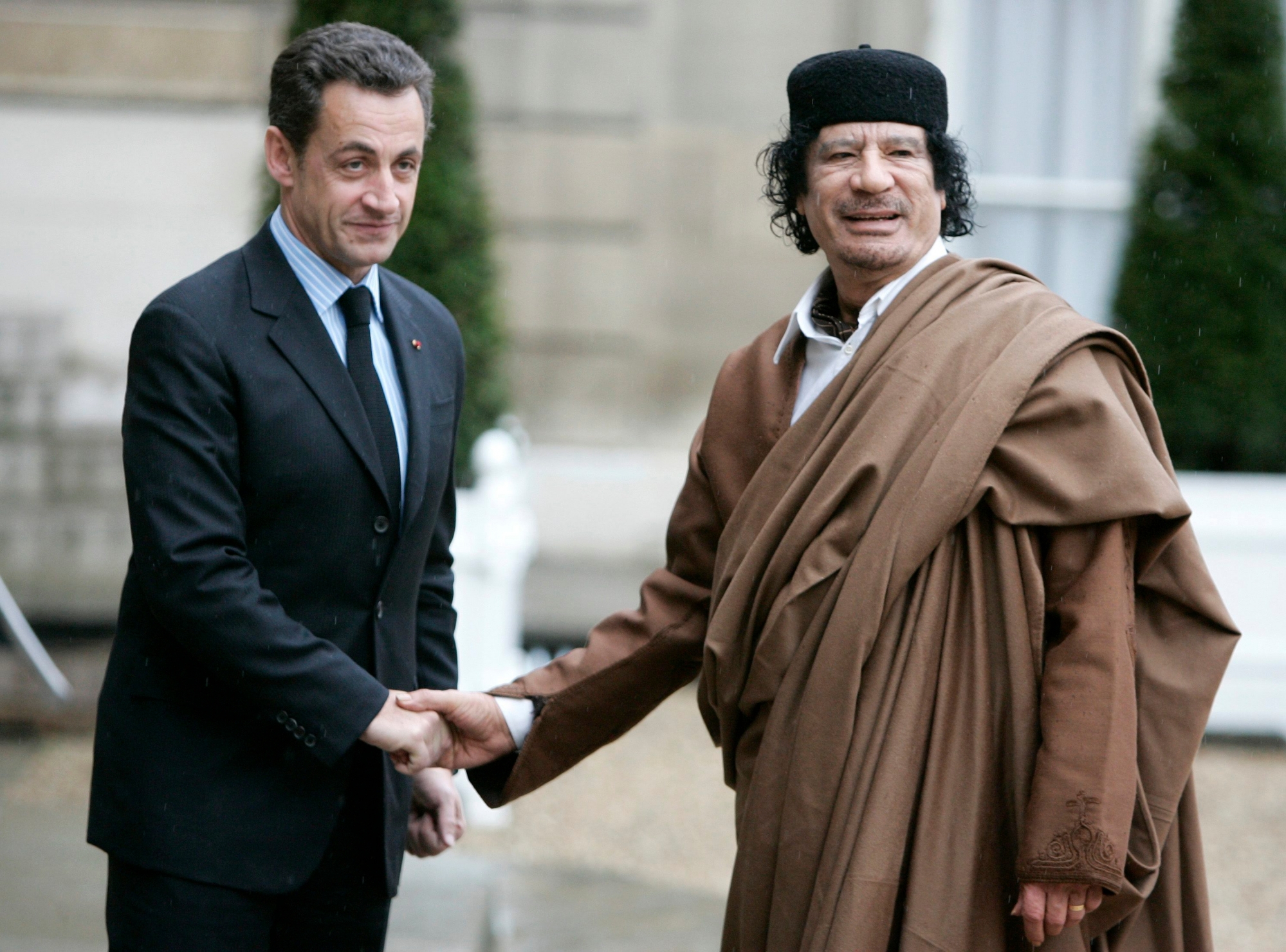 FILE - In this Dec. 10 2007 file photo, French President Nicolas Sarkozy, left, greets Libyan leader Col. Moammar Gadhafi upon his arrival at the Elysee Palace, in Paris. Former French President Nicolas Sarkozy was placed in custody on Tuesday March 20, 2018as part of an investigation that he received millions of euros in illegal financing from the regime of the late Libyan leader Moammar Gadhafi. (AP Photo/Francois Mori) France Sarkozy