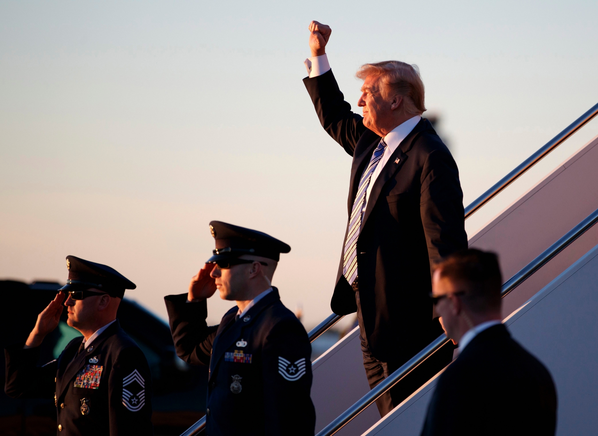 President Donald Trump gestures to people cheering him across the tarmac as he, arrives on Air Force One with first lady Melania Trump and their son Barron Trump at Palm Beach International Airport, in West Palm Beach, Fla., Friday, March 23, 2018. (AP Photo/Carolyn Kaster) Trump