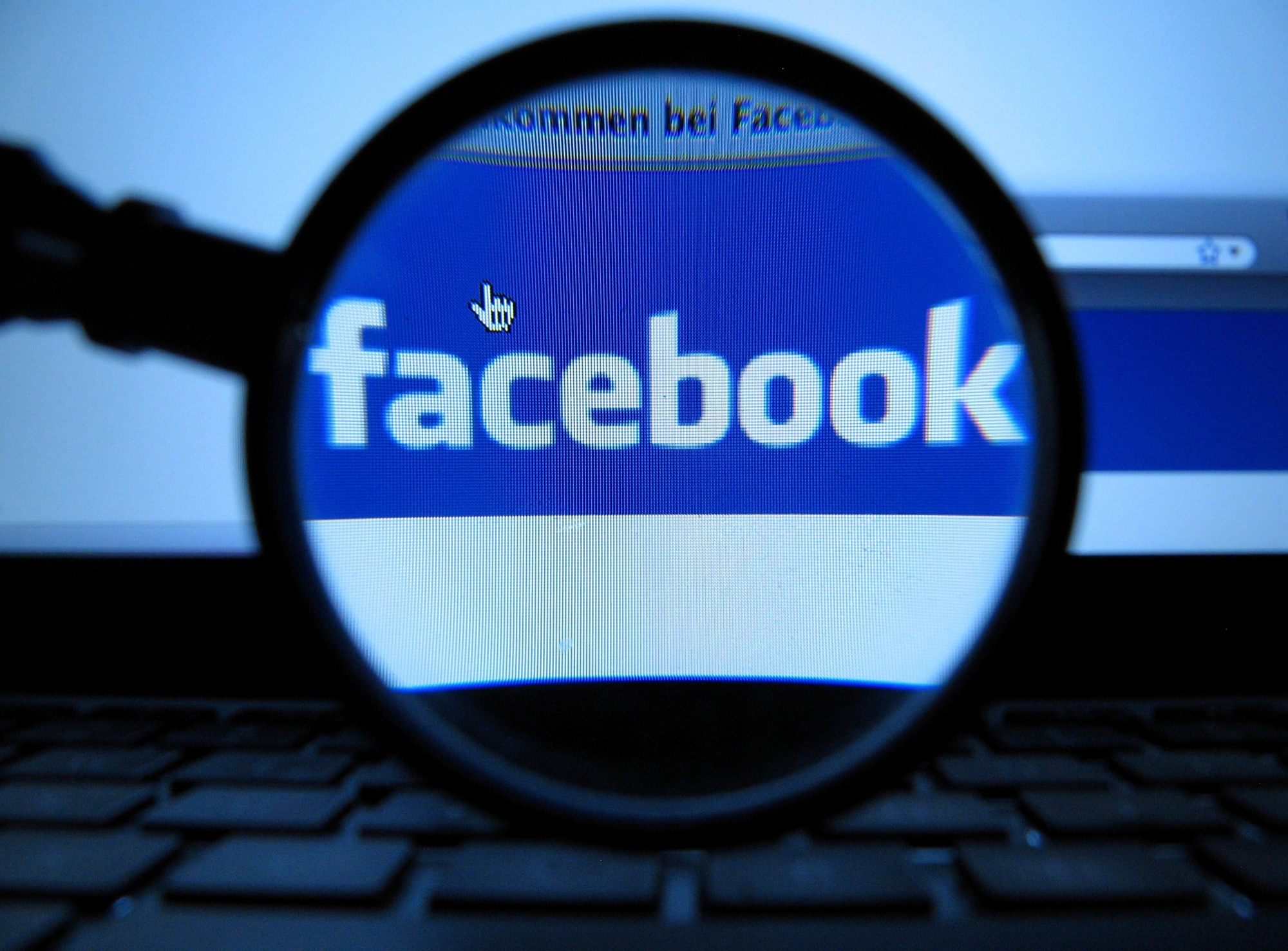FILE - In this Oct. 10, 2011 file photo, a magnifying glass is posed over a monitor displaying a Facebook page in Munich. Taking a company public isn't as simple as collecting Facebook friends. Even if the company is Facebook. (AP Photo/dapd, Joerg Koch) Facebook IPO Q and A