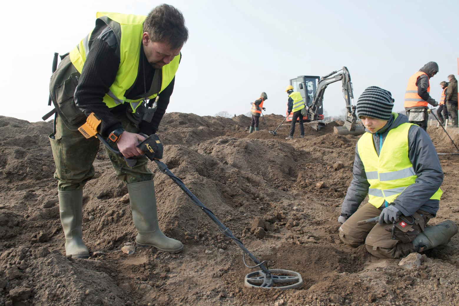 In this April 13, 2018 photo hobby archaeologist Rene Schoen and 13-year-old  Luca Malaschnitschenko, right, search for coins after a medieval silver treasure had been found near Schaprode on the northern German island of Ruegen in the Baltic Sea.  (Stefan Sauer/dpa via AP) Germany Silver Treasure