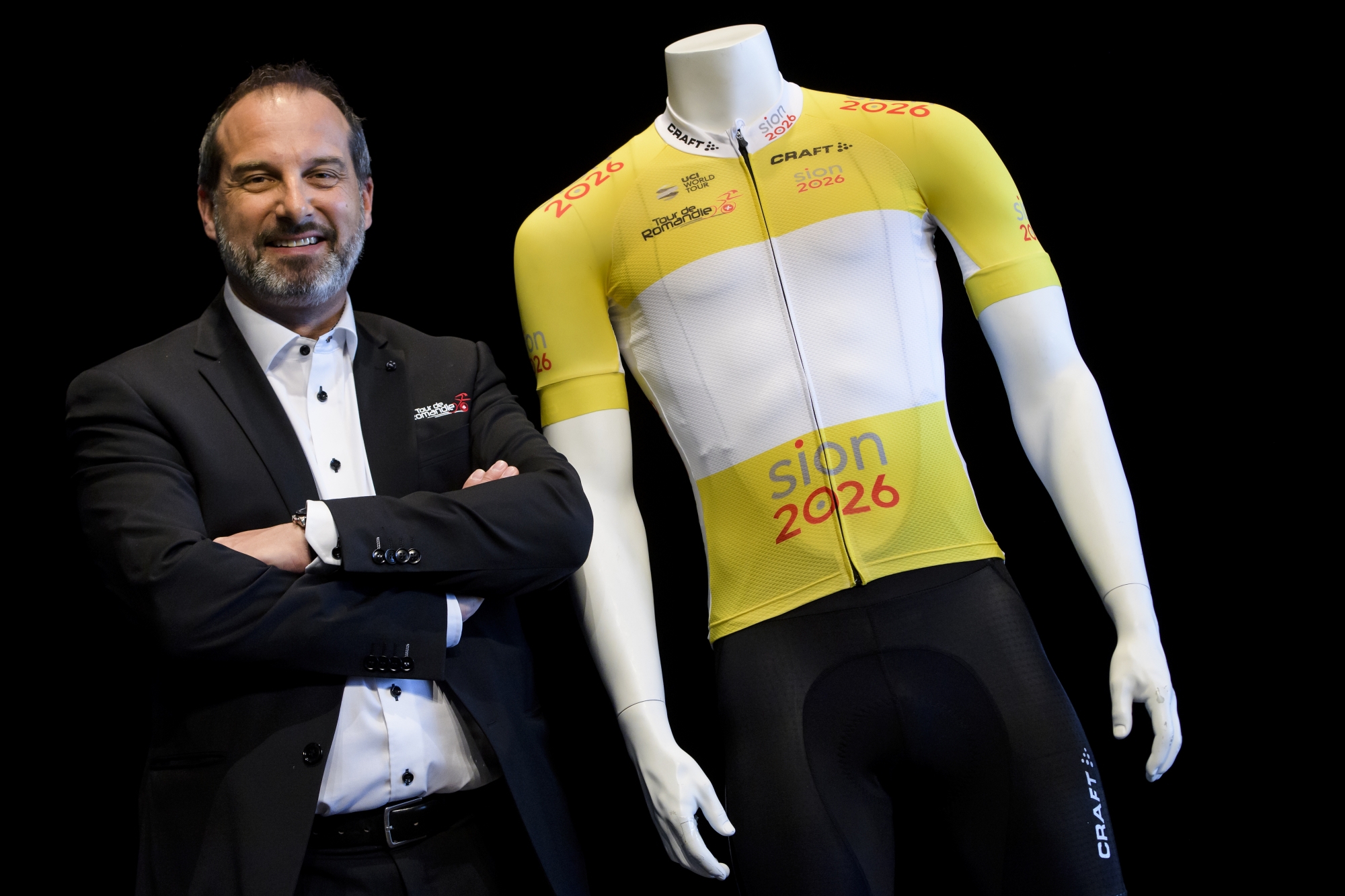 Richard Chassot, directeur général du Tour de Romandie, au côté du maillot jaune de leader, lequel arbore la candidature Sion 2026. 