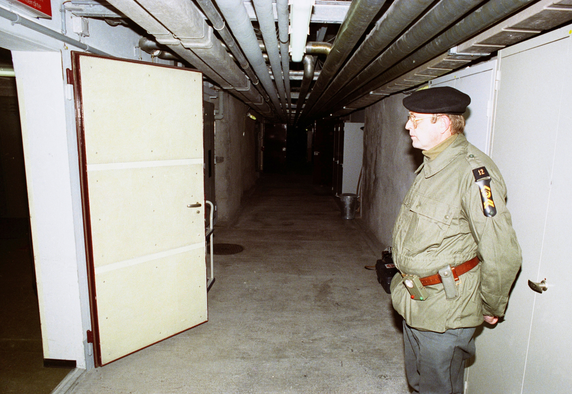 Ein Unteroffizier steht anlaesslich einer Pressefuehrung zur Information ueber die Geheimarmee P-26 in einem Durchgang der unterirdischen Bunkeranlage bei Gstaad im Berner Oberland, aufgenommen am 7. Dezember 1990. Der Stuetzpunkt diente der Geheimorganisation als Waffenlager und Ausbildungsanlage. (KEYSTONE/Str) SCHWEIZ GEHEIMARMEE P-26