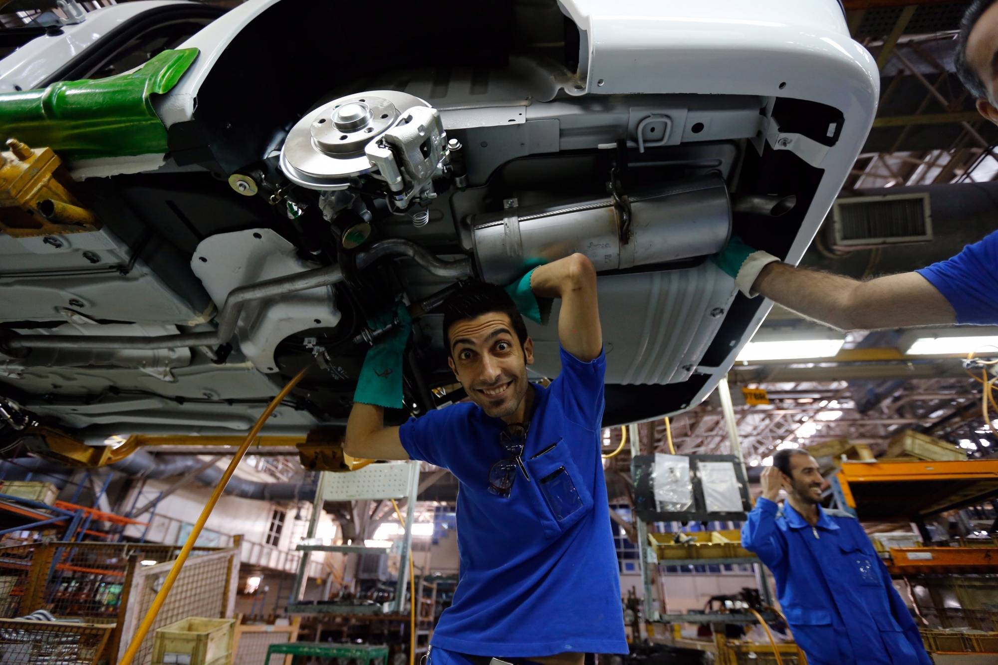 epa04441890 Iranian workers work at the Iranian automobile manufacturing company Iran-Khodro, in Tehran, Iran, 11 October 2014. Iran-Khodro is the leading Iranian vehicle manufacturer that mainly assembles the Iranian brand Samand as well as the French Peugueot for both local market and exports to neighboring countries. The companyÄôs turnover contributes with a major part of the country's non-oil revenue. Despite the international sanctions imposed on Iran due to the country's controversial nuclear program, Iran-Khodro is trying to produce all necessary spare parts by itself.  EPA/ABEDIN TAHERKENAREH IRAN INDUSTRIE AUTO KHODRO