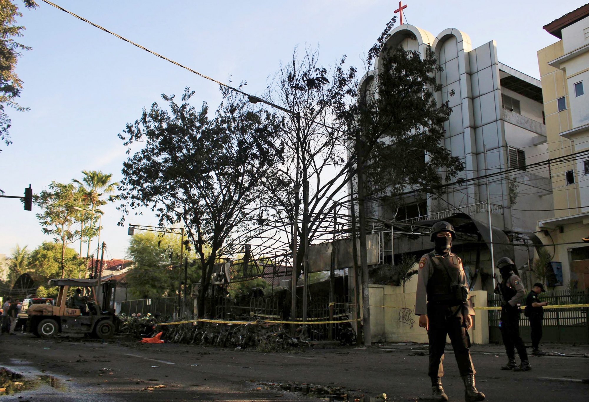 epa06732578 Indonesian police officers stand guard at the site of a bomb blast in front of a church in Surabaya, East Java, Indonesia, 13 May 2018. According to media reports, at least eleven people have been killed and dozens of others were injured after bomb blasts occurred at three locations in Surabaya.  EPA/STRINGER INDONESIA BOMB BLAST