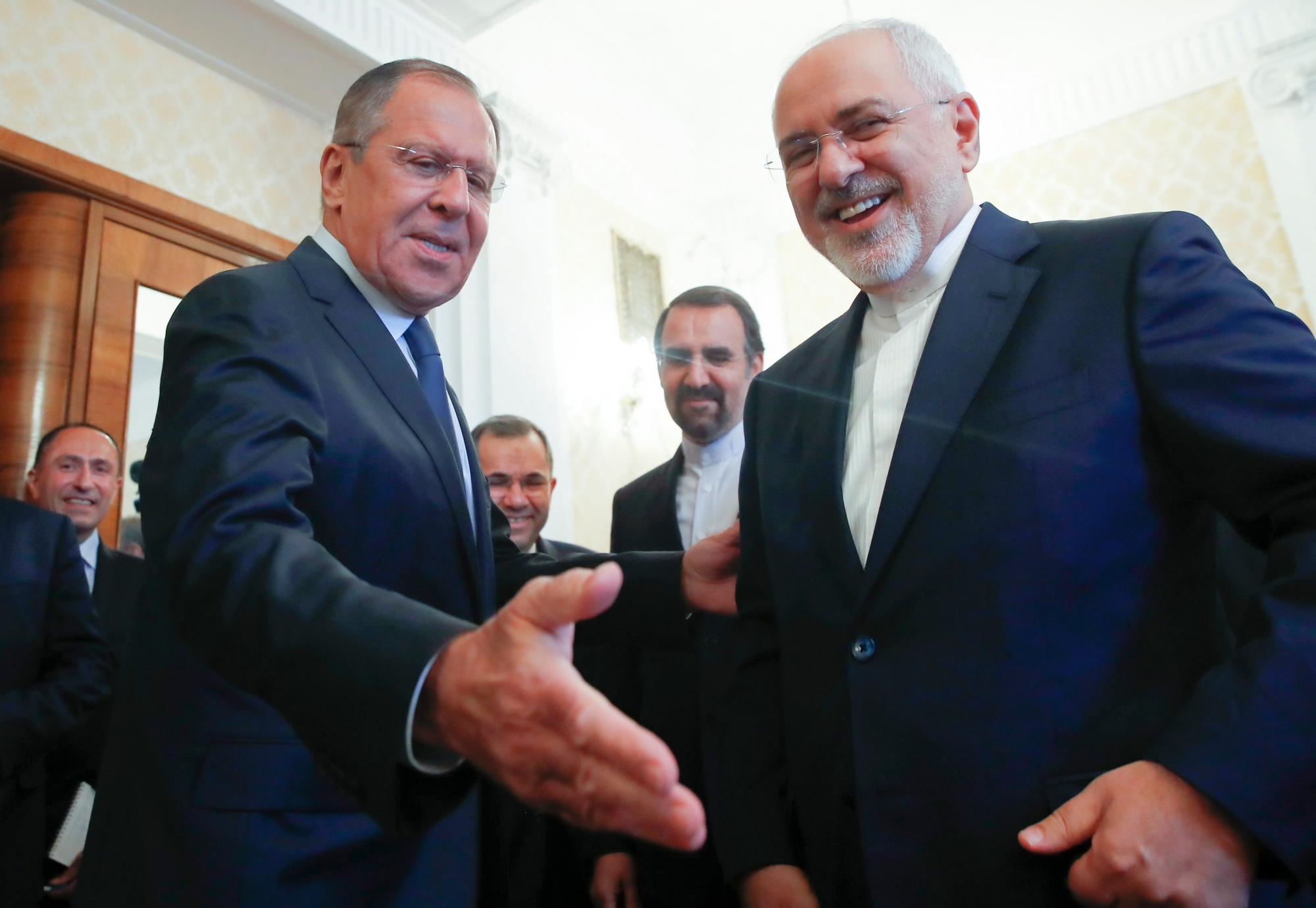 Russian Foreign Minister Sergey Lavrov, left, welcomes his Iranian counterpart Mohammad Javad Zarif ahead of their meeting in Moscow, Russia, Monday, May 14, 2018. Lavrov calls on participants in Iran nuclear deal to cooperate in defending legitimate interests. (Maxim Shemetov/Pool Photo via AP) Russia Iran