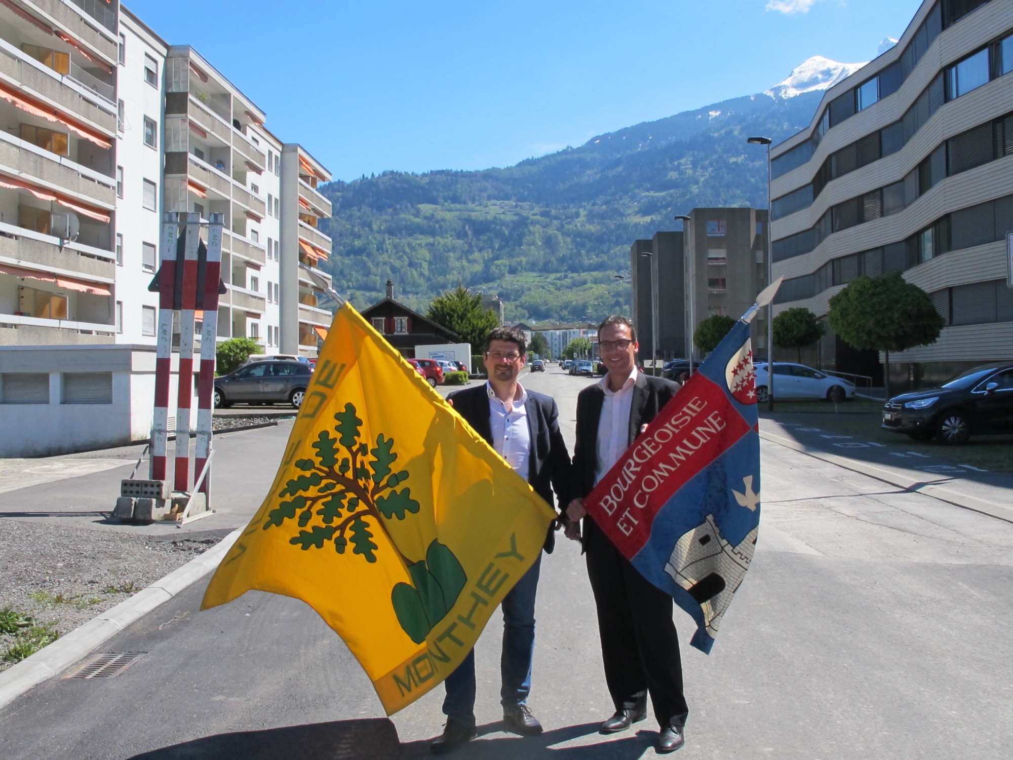 Yannick Buttet, président de Collombey-Muraz et Stéphane Coppey, président de Monthey, prennent la pose avec le drapeau de leur voisin.