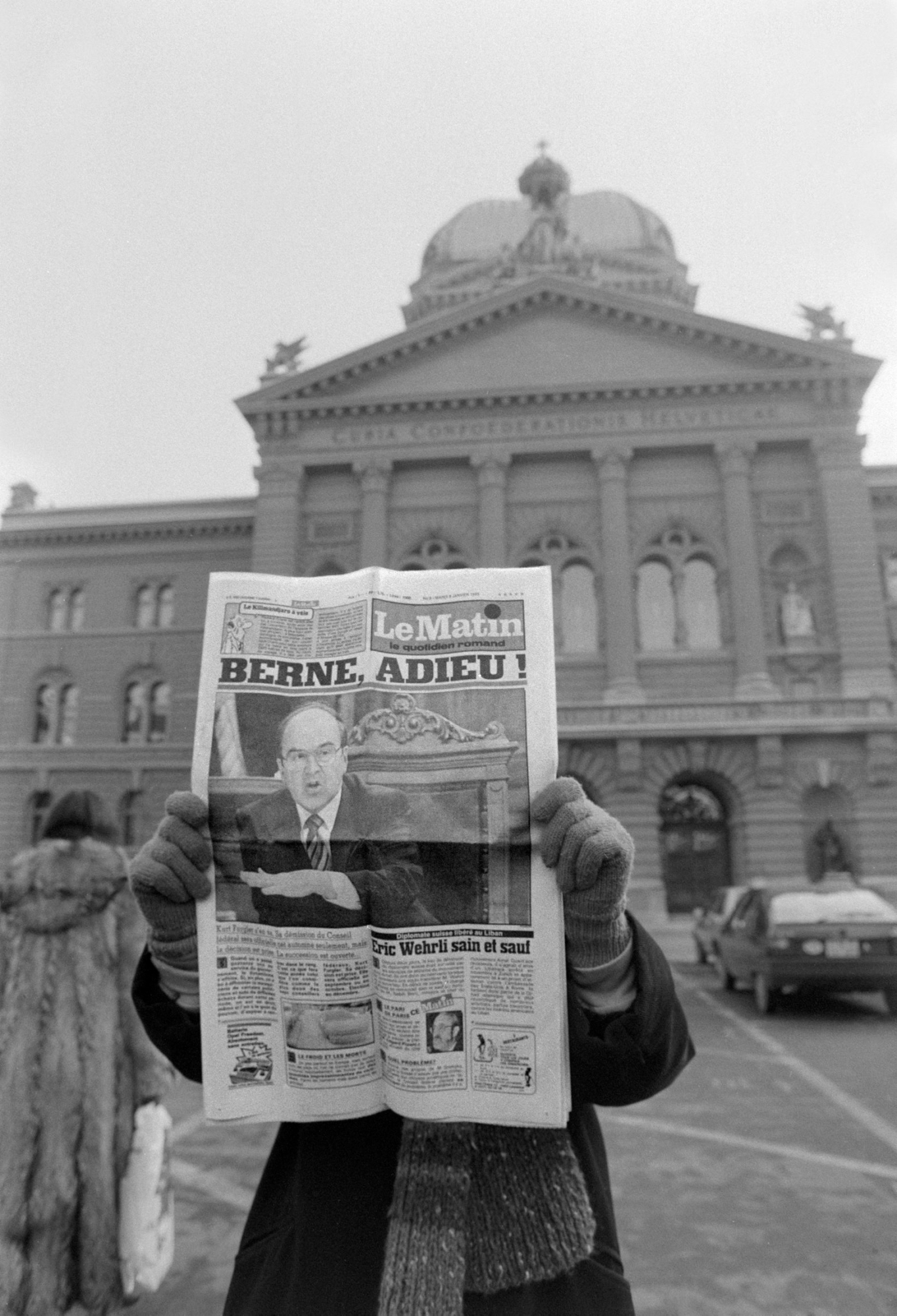 THEMENBILD ZUR EINSTELLUNG DER LE MATIN PRINTAUSGABE DURCH DEN MUTTERKONZERN TAMEDIA --- On January 8, 1985, a person stands in front of the Federal Parliament in Bern and presents the front page of the French-Swiss newspaper "Le Matin", after which Federal Councillor Kurt Furgler's announcement of his resignation is addressed in the headline "Berne, adieu!". (KEYSTONE/Str)

Eine Person steht am 8. Januar 1985 vor dem Bundeshaus in Bern und praesentiert das Titelblatt der Westschweizer Zeitung "Le Matin", worauf mit der Schlagzeile "Berne, adieu!" Bundesrat Kurt Furglers Ankuendigung zu seinem Ruecktritt thematisiert wird. (KEYSTONE/Str) SCHWEIZ LE MATIN EINSTELLUNG PRINT