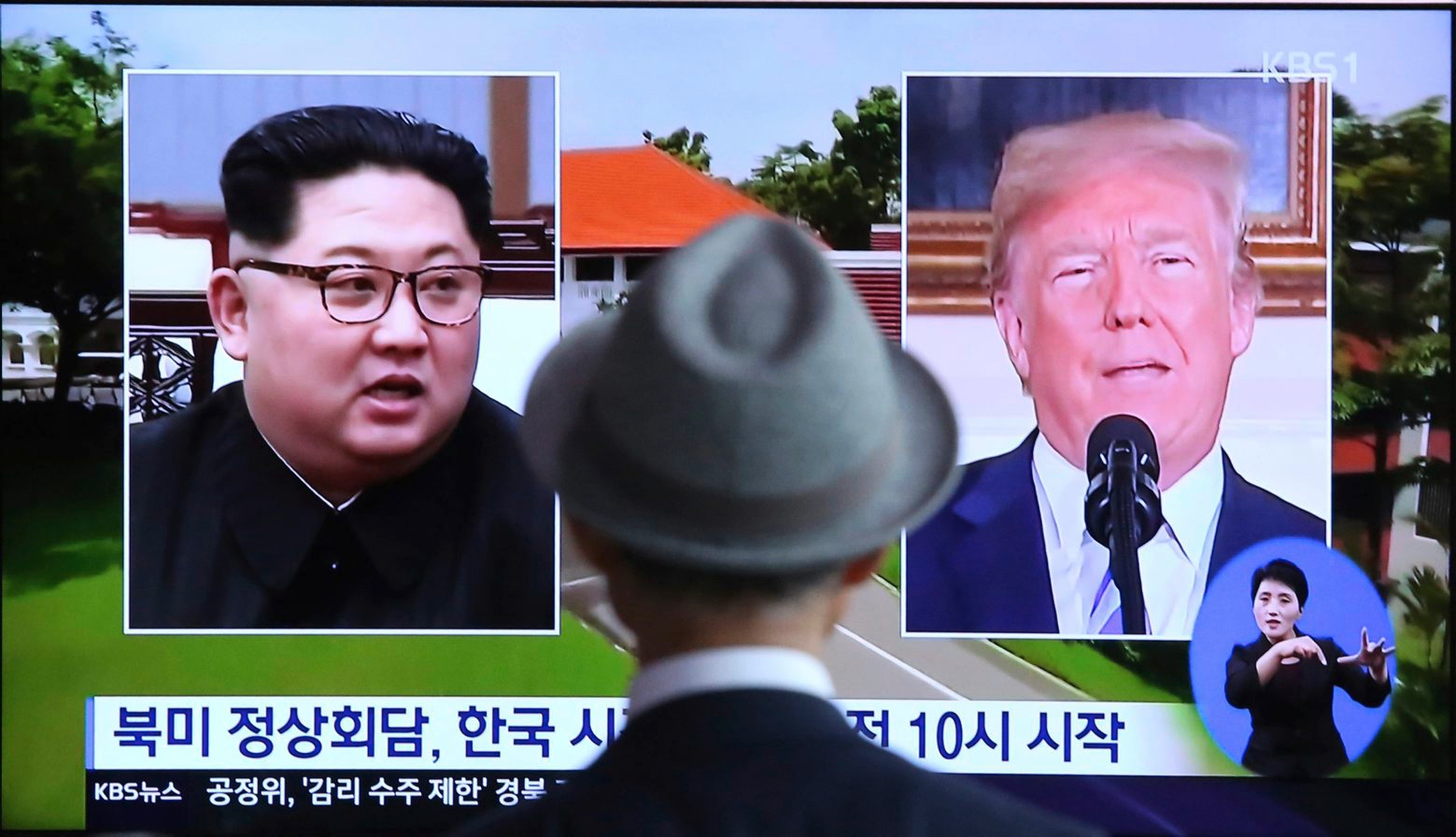 A man watches a TV screen showing file footage of U.S. President Donald Trump, right, and North Korean leader Kim Jong Un during a news program at the Seoul Railway Station in Seoul, South Korea, Monday, June 11, 2018.  Final preparations are underway in Singapore for Tuesday's historic summit between President Trump and North Korean leader Kim, including a plan for the leaders to kick things off by meeting with only their translators present, a U.S. official said.  The signs read: " Summit between the United States and North Korea." (AP Photo/Ahn Young-joon) South Korea Trump Kim Summit