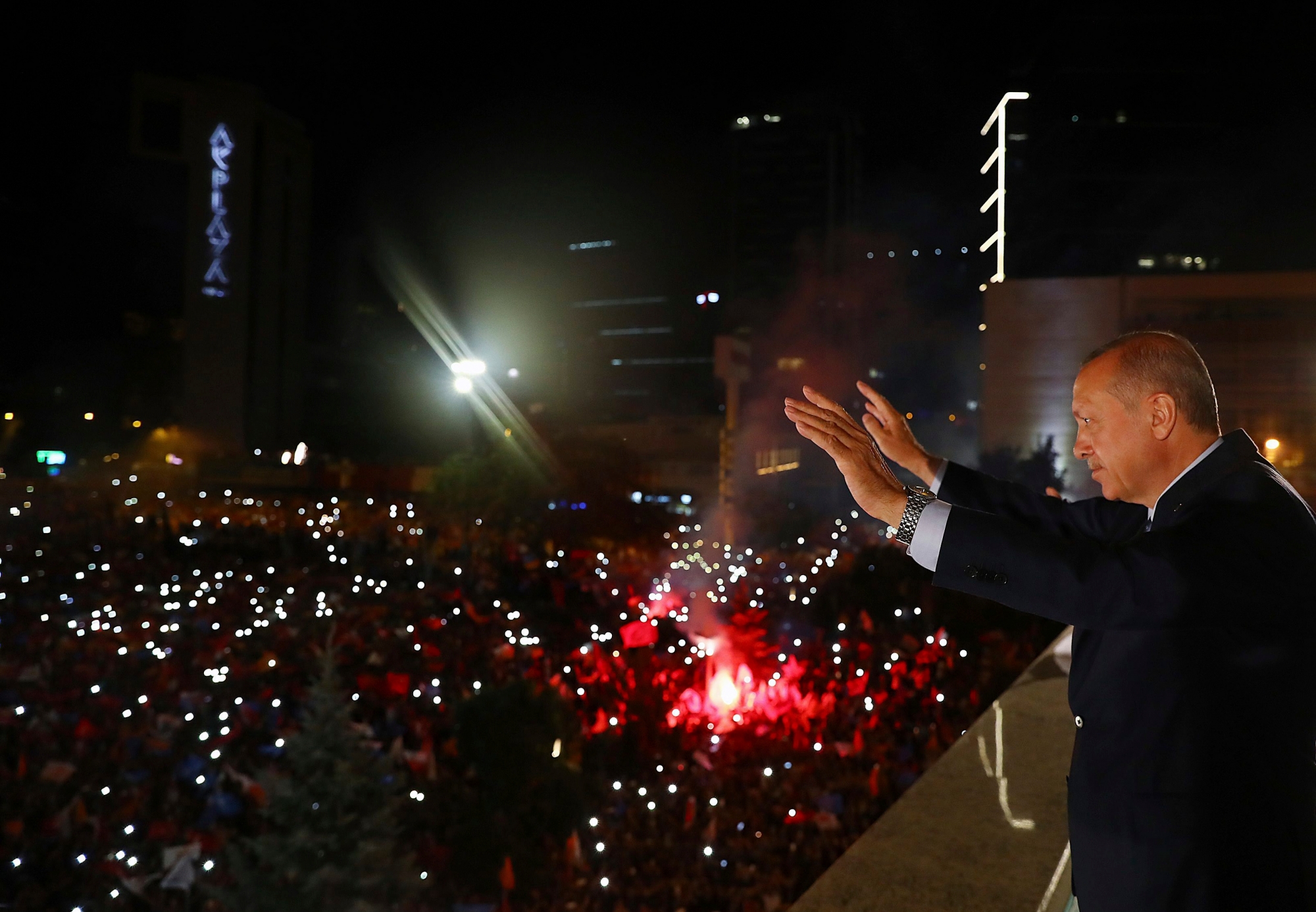 Turkey's President Recep Tayyip Erdogan, waves to supporters of his ruling Justice and Development Party (AKP) in Ankara, Turkey, early Monday, June 25, 2018. Erdogan won Turkey's landmark election Sunday, the country's electoral commission said, ushering in a new system granting the president sweeping new powers which critics say will cement what they call a one-man rule (Presidency Press Service via AP, Pool) Turkey Elections