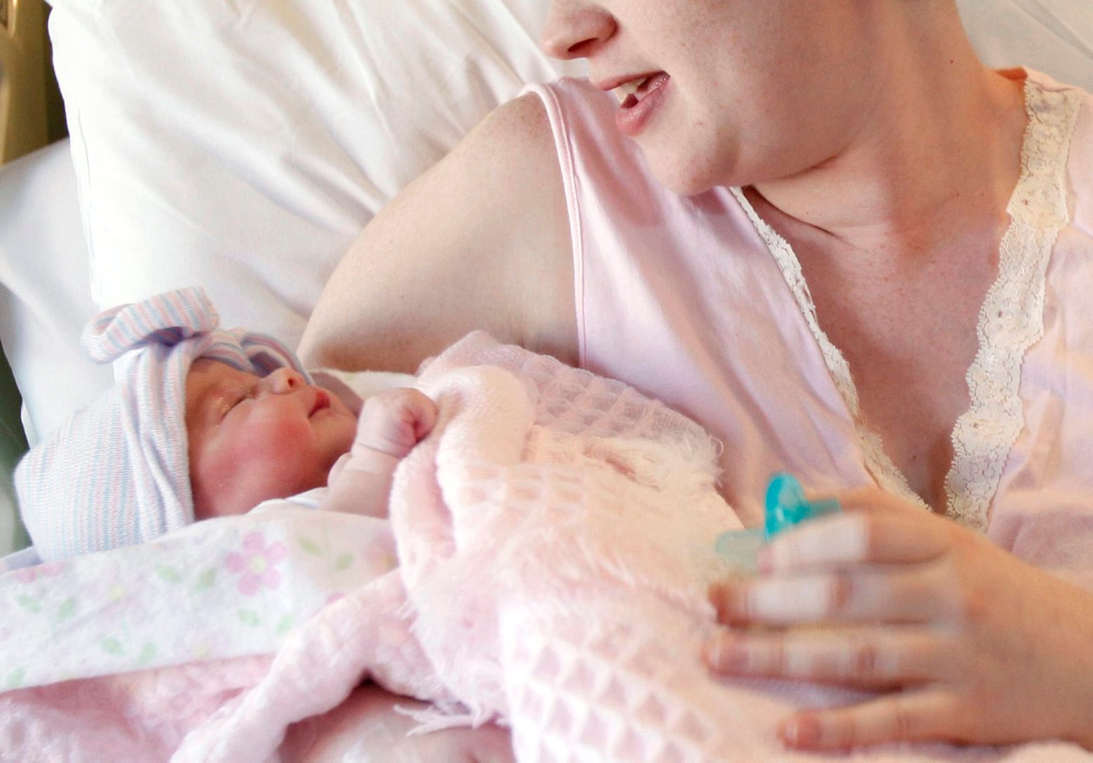 FILE - In this Nov. 11, 2011, file photo, a mother holds her newborn baby at a hospital in Corpus Christi, Texas. Noon is the most common time of day for babies to be born without help, according to a first-of-its-kind federal report released on Friday, May 8, 2015. (Michael Zamora/Corpus Christi Caller-Times via AP) Baby Births