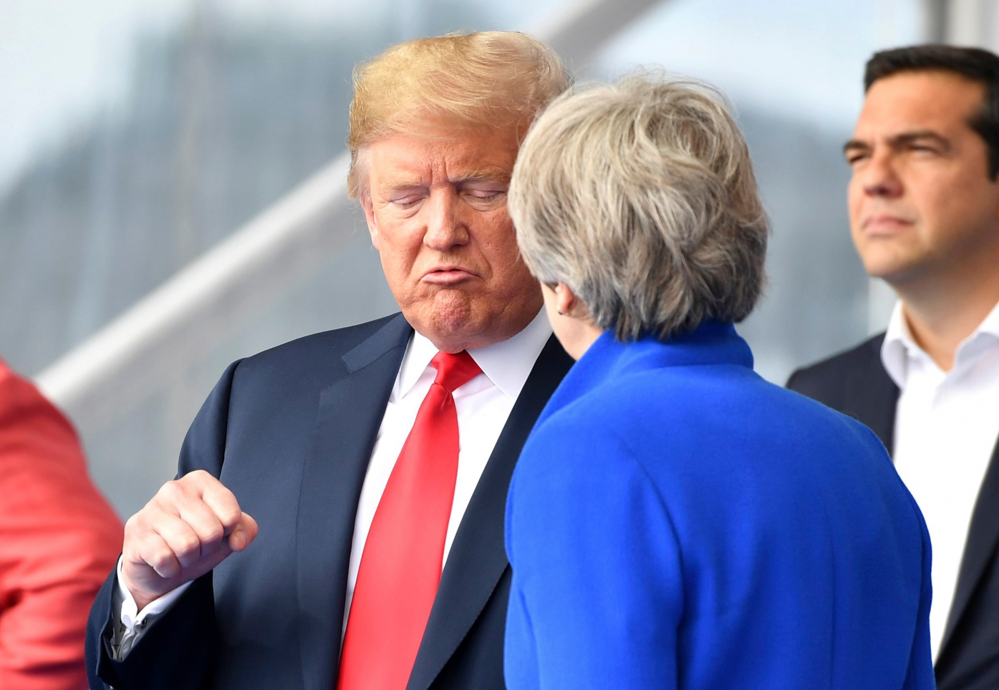U.S. President Donald Trump, left, clenches a fist when talking to British Prime Minister Theresa May during a summit of heads of state and government at NATO headquarters in Brussels on Wednesday, July 11, 2018. NATO leaders gather in Brussels for a two-day summit to discuss Russia, Iraq and their mission in Afghanistan. (AP Photo/Geert Vanden Wijngaert) APTOPIX Belgium NATO Summit