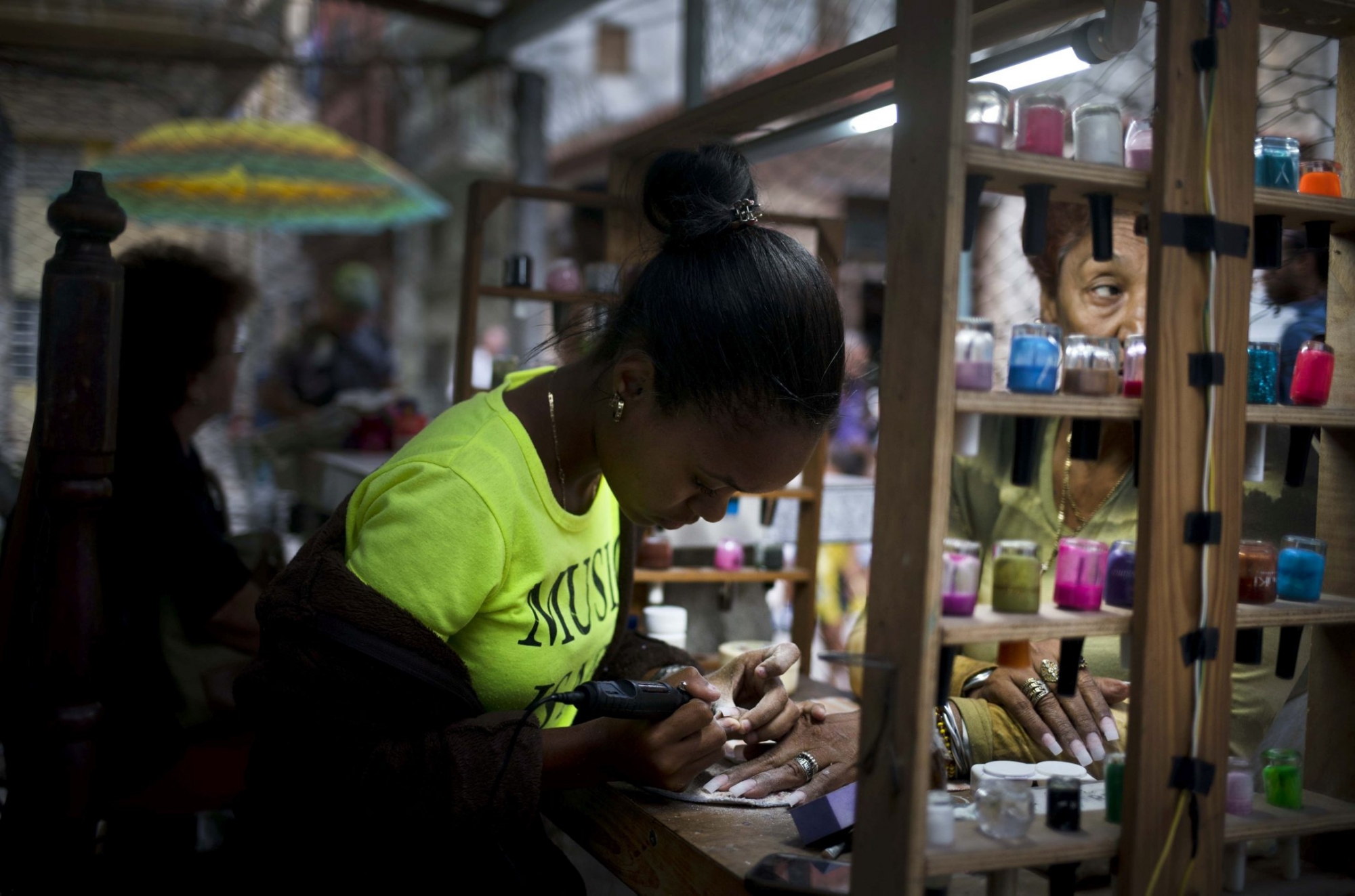 A private manicurist, who is part of a cooperative, services a client in Havana, Cuba, Wednesday, Jan. 31, 2018. Cuba's once-promising worker-owned cooperative sector has shown little recent growth, while the state-run economy responsible for 70-80 percent of GDP is stagnant, and President Raul Castro has put the breaks on private enterprise. (AP Photo/Ramon Espinosa) CUBA PRIVATE BUSINESS