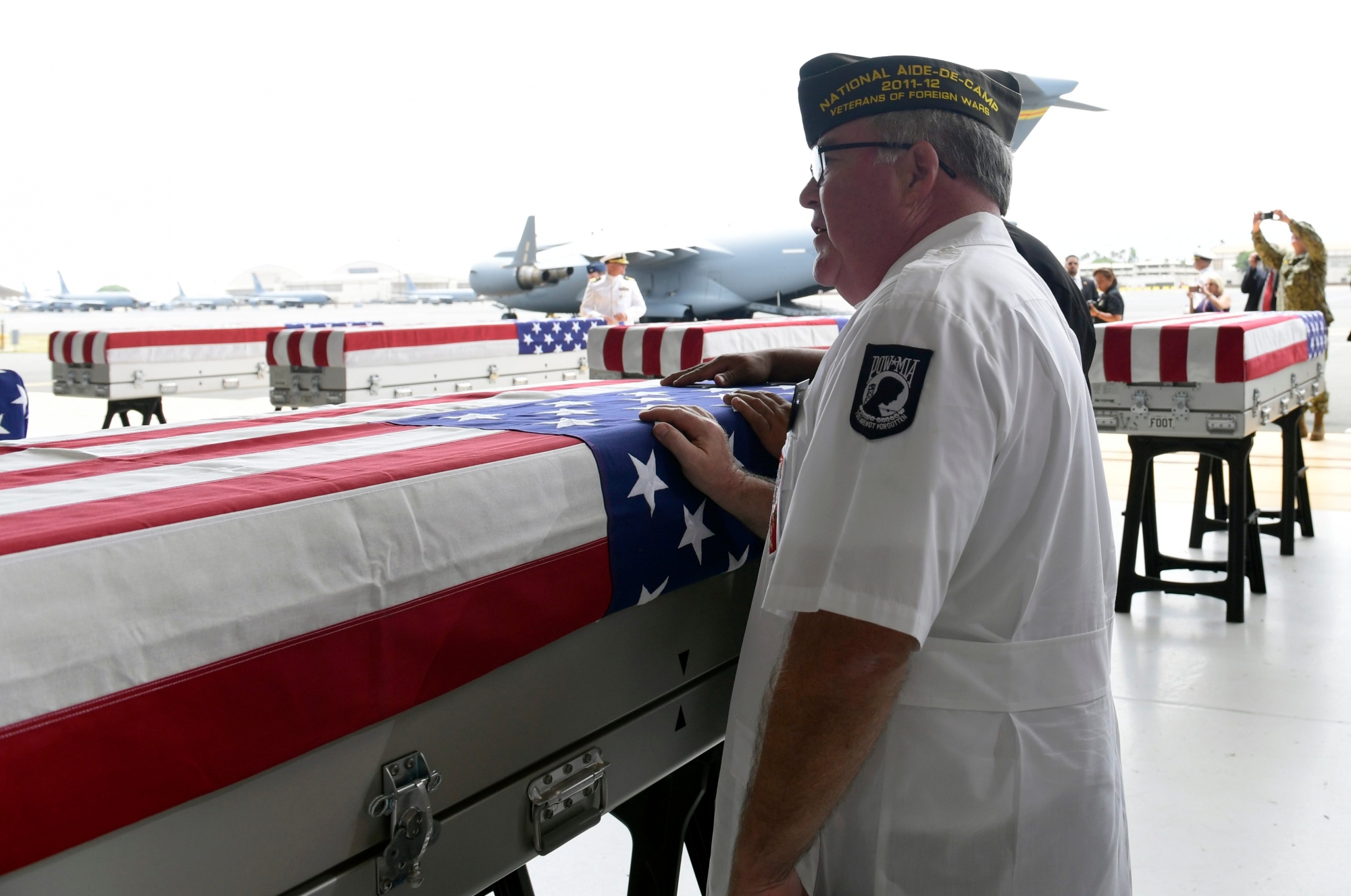 Members of the audience pause at a transfer case after at a ceremony marking the arrival of the remains believed to be of American service members who fell in the Korean War at Joint Base Pearl Harbor-Hickam in Hawaii, Wednesday, Aug. 1, 2018. North Korea handed over the remains last week. (AP Photo/Susan Walsh) US Korea War Remains