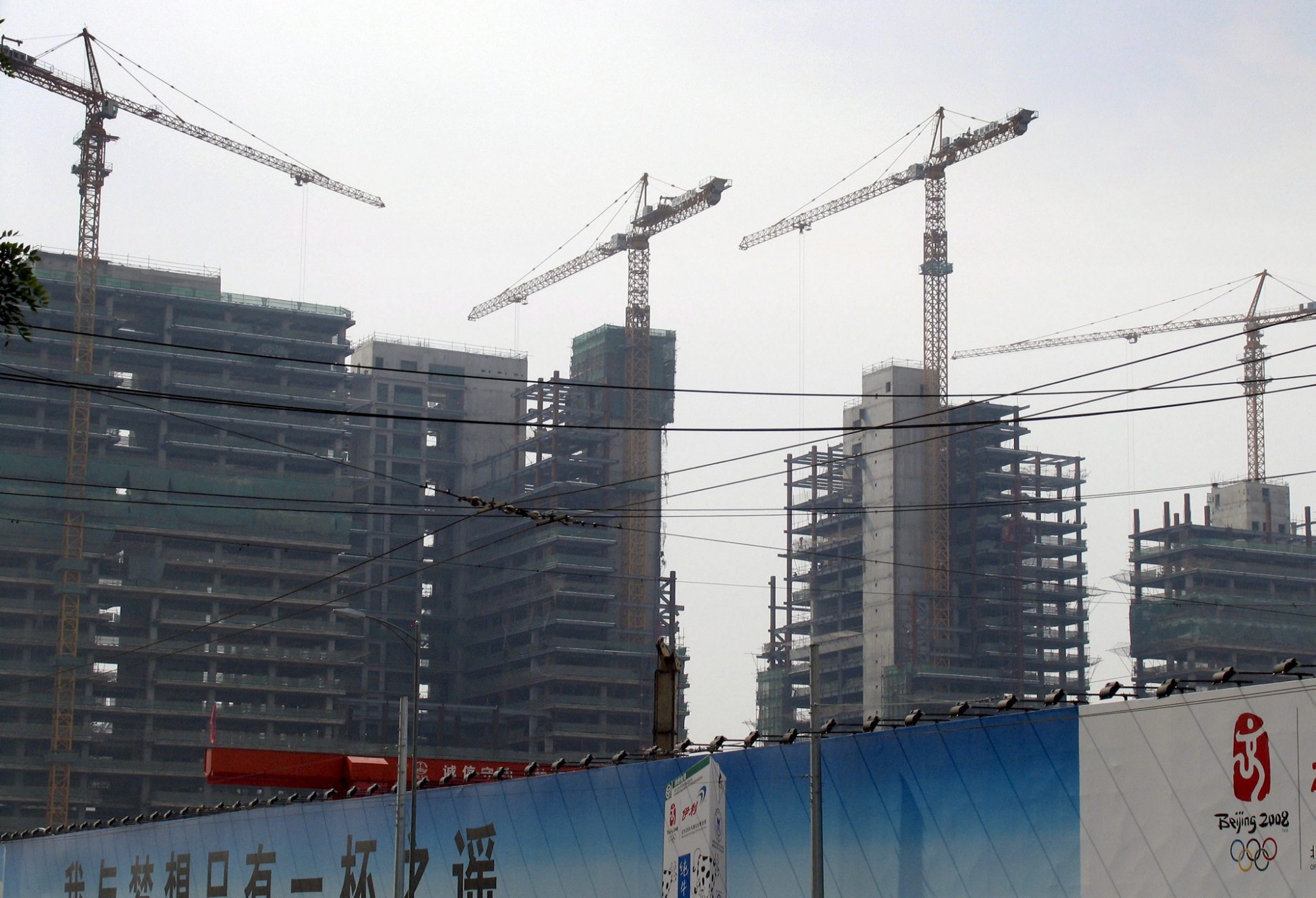 epa00726538 Tower blocks rise over a 2008 Olympics logo in Beijing Monday 29 May 2006. Despite increasing pressure from the government to cool property development Beijing is dominated by large scale construction sites rushing to beat the deadline of end 2007 when all cranes and building sites in the Chinese capital must be removed in time for the dust to settle before the 2008 Olympics.  EPA/ADRIAN BRADSHAW CHINA CONSTRUCTION