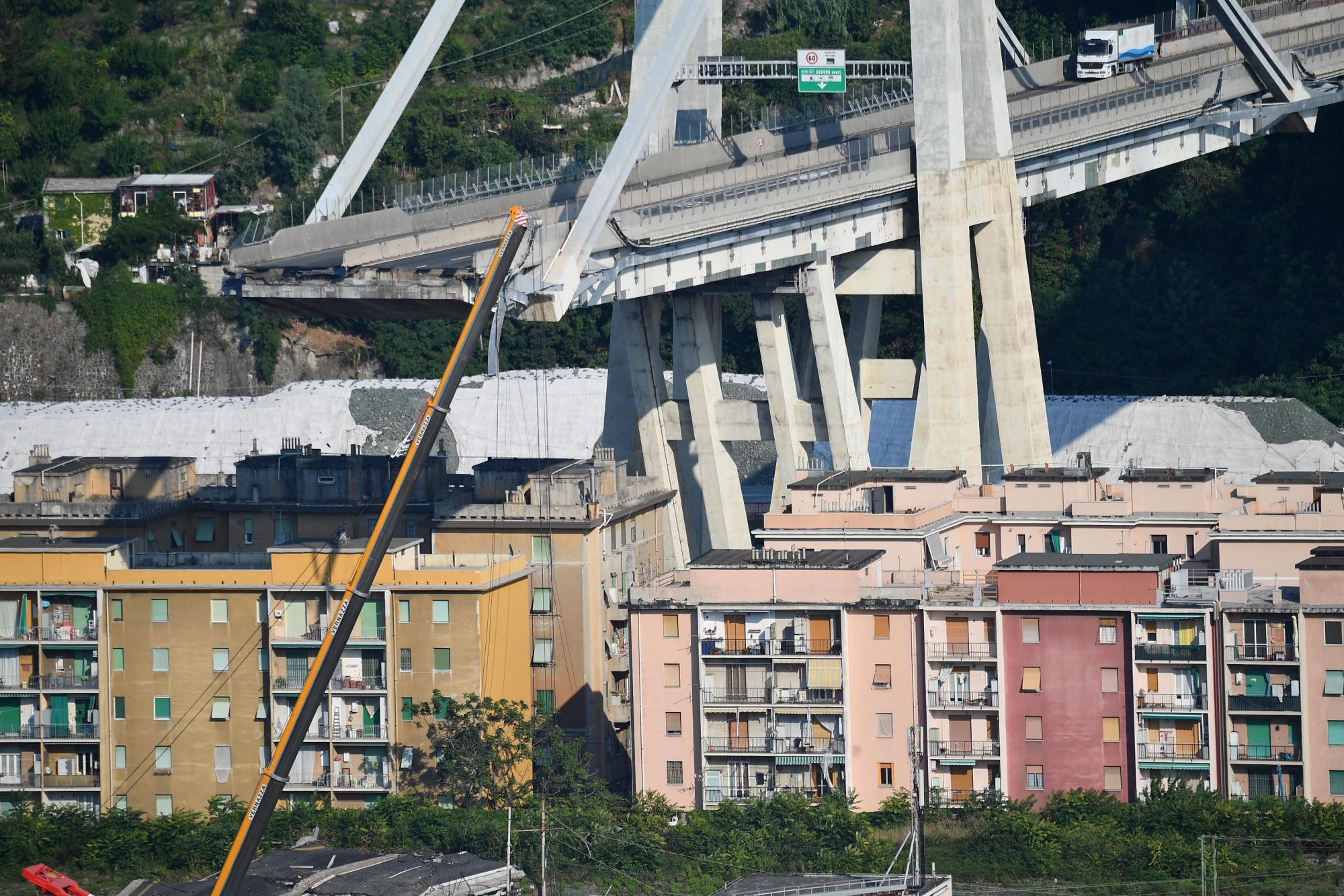 epa06958795 A general view showing a part of the partially collapsed Morandi bridge, in Genoa, Italy, 19 August 2018. Italian authorities, worried about the stability of remaining large sections of the bridge, evacuated about 630 people from nearby apartments. The Morandi bridge partially collapsed on 14 August, killing at least 41 people.  EPA/LUCA ZENNARO ITALY GENOA MORANDI BRIDGE COLLAPSE AFTERMATH