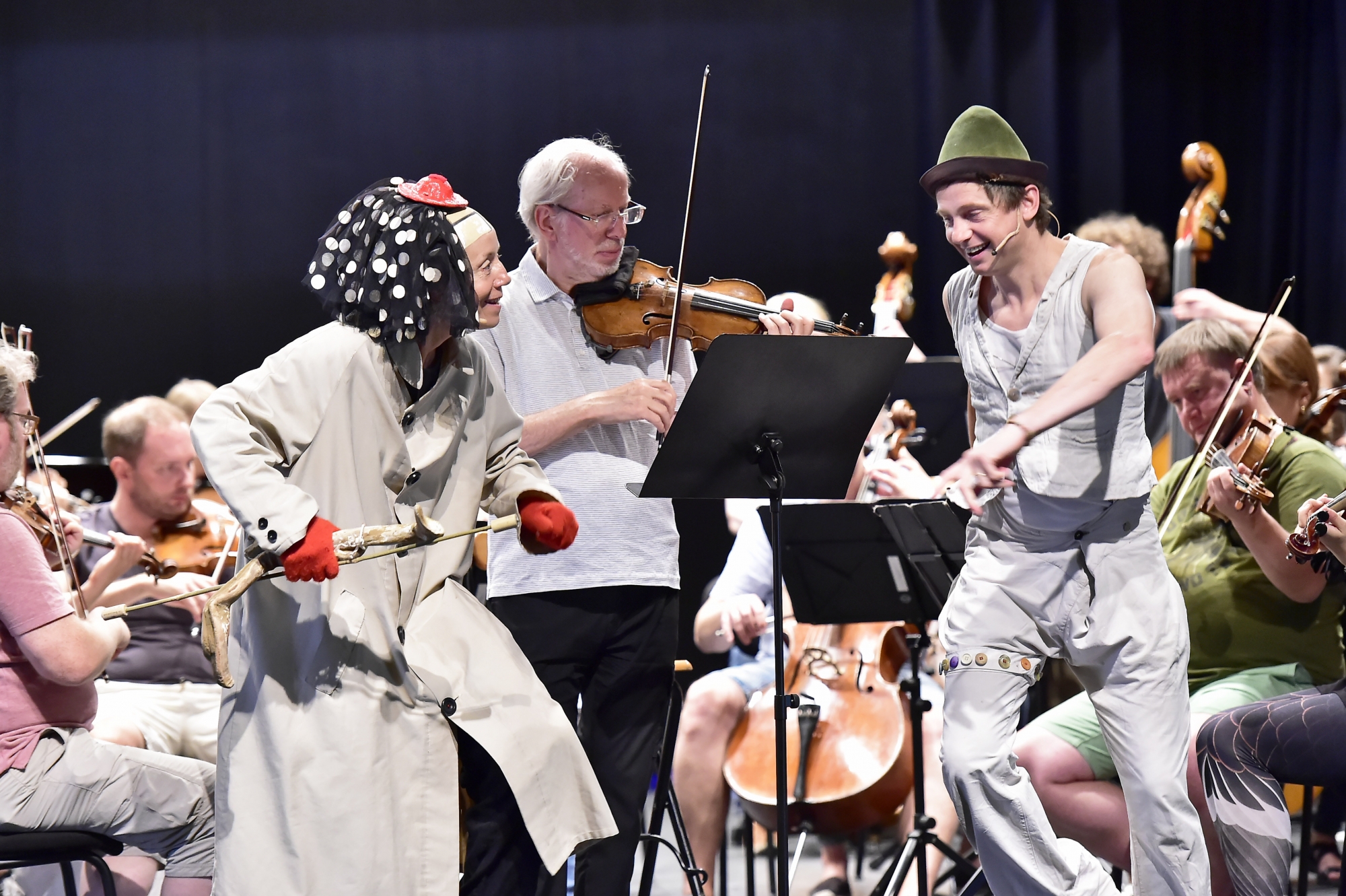 Lors de la répétition, Gidon Kremer entouré des clowns Catherine Germain et Julien Cottereau et accompagné par son ensemble, Kremerata Baltica.