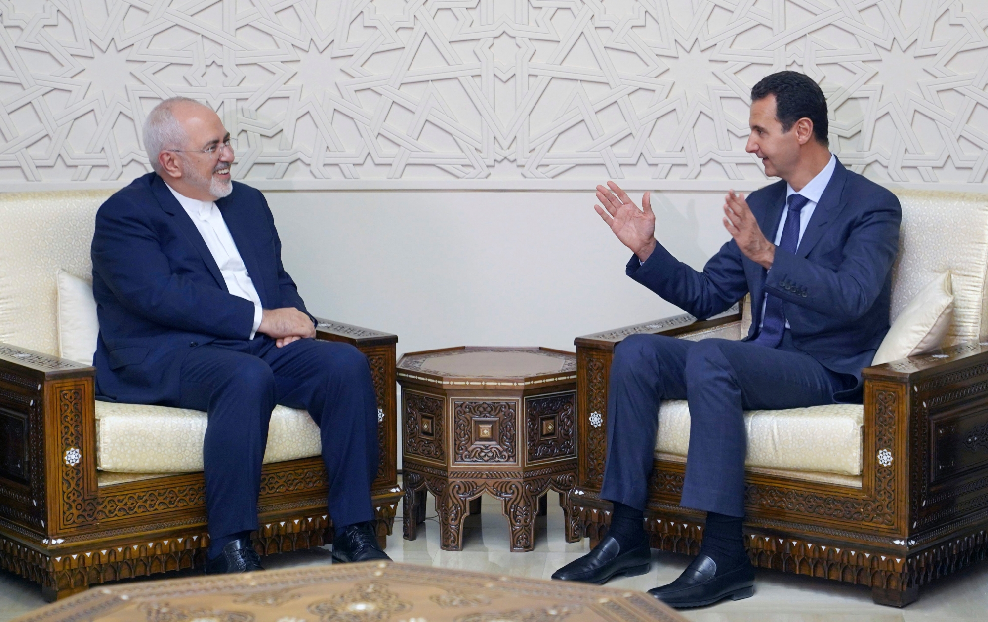 In this photo released by the Syrian official news agency SANA, Syrian President Bashar Assad, right, speaks with Iranian Foreign Minister Mohammad Javad Zarif in Damascus, Syria, Monday, Sept 3, 2018. Zarif said at the start of a visit to Damascus on Monday that "terrorists must be purged" from Syria's Idlib and the entire northwestern province returned to government control. (SANA via AP) Syria