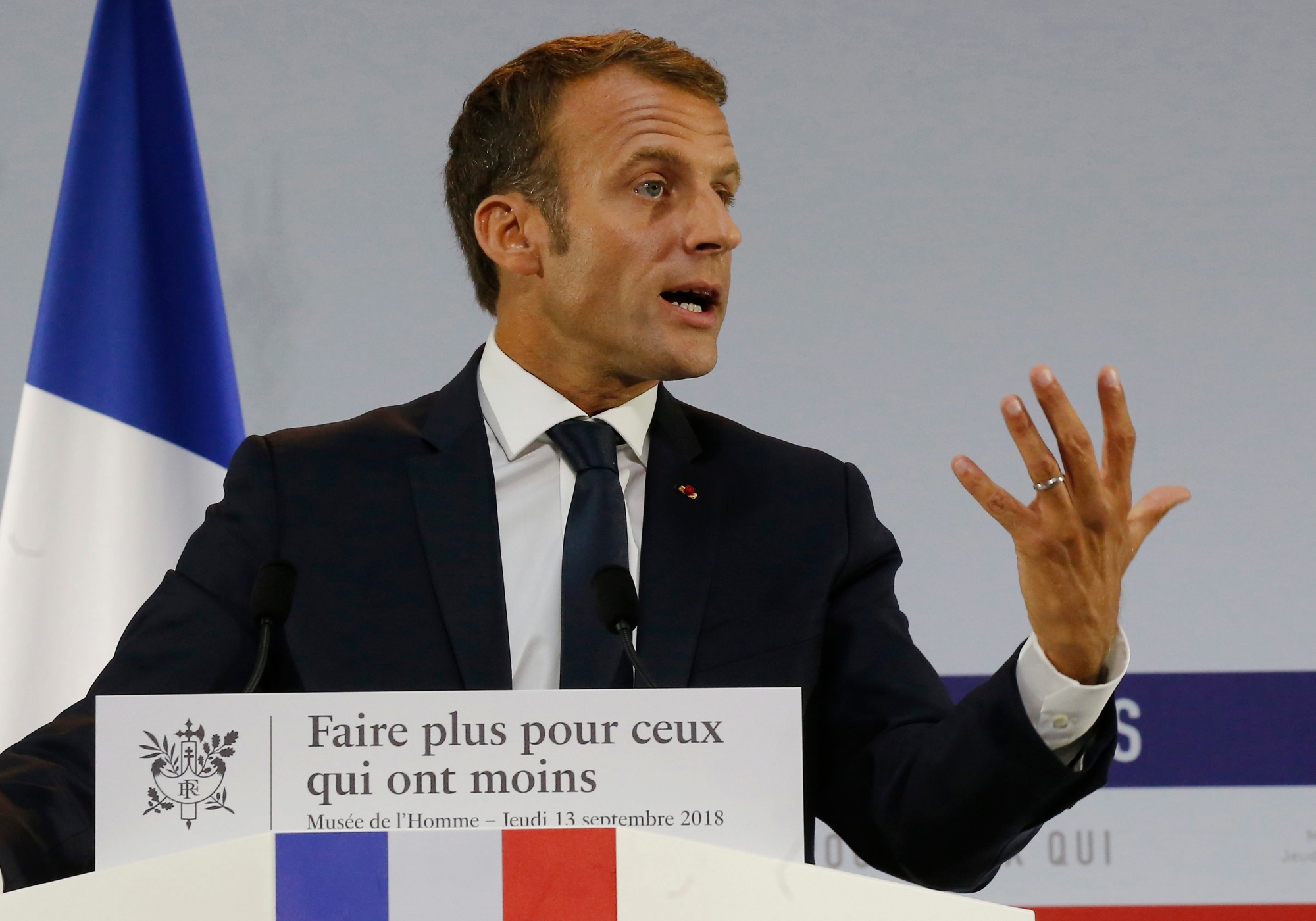 French President Emmanuel Macron delivers a speech on poverty to social aid workers in Paris, France, Thursday, Sept. 13, 2018. French President Emmanuel Macron has unveiled a 8-billion euro plan focusing on education and getting the unemployed back to work in an effort to combat poverty. Placard reads "make more for those who have less". (AP Photo/Michel Euler, Pool) France Macron Poverty