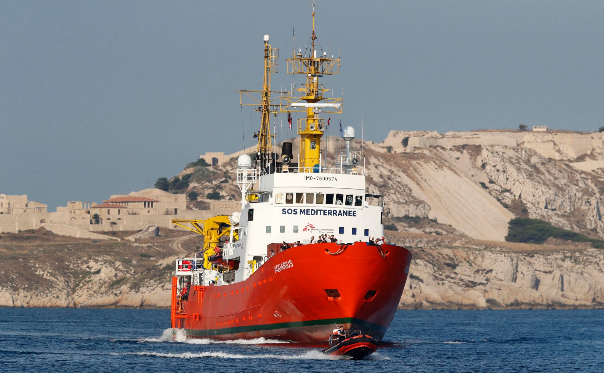 epa06849218 Crew members of the search and rescue vessel 'Aquarius' of NGO 'SOS Mediterranee' wave from the ship's bow as the vessel arrives in the port of Marseille, France, 29 June 2018. The 'Aquarius' arrives in the port for a five-days stop and check up after rescue operations in the Mediterranean Sea.  EPA/GUILLAUME HORCAJUELO FRANCE MIGRATION RESCUE