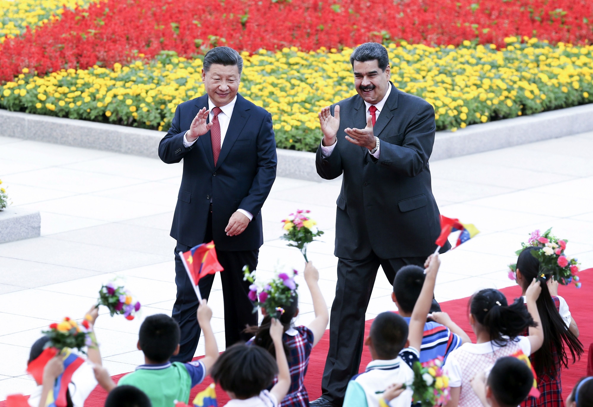 In this Friday, Sept. 14, 2018, photo released by China's Xinhua News Agency, Chinese President Xi Jinping, left, and Venezuela's President Nicolas Maduro react during a welcome ceremony in Beijing. Venezuelan President Nicolas Maduro met Friday with Chinese President Xi Jinping during a trip to deepen ties and seek increased financial support from one of his ailing country's biggest creditors. (Yao Dawei/Xinhua via AP) China Venezuela