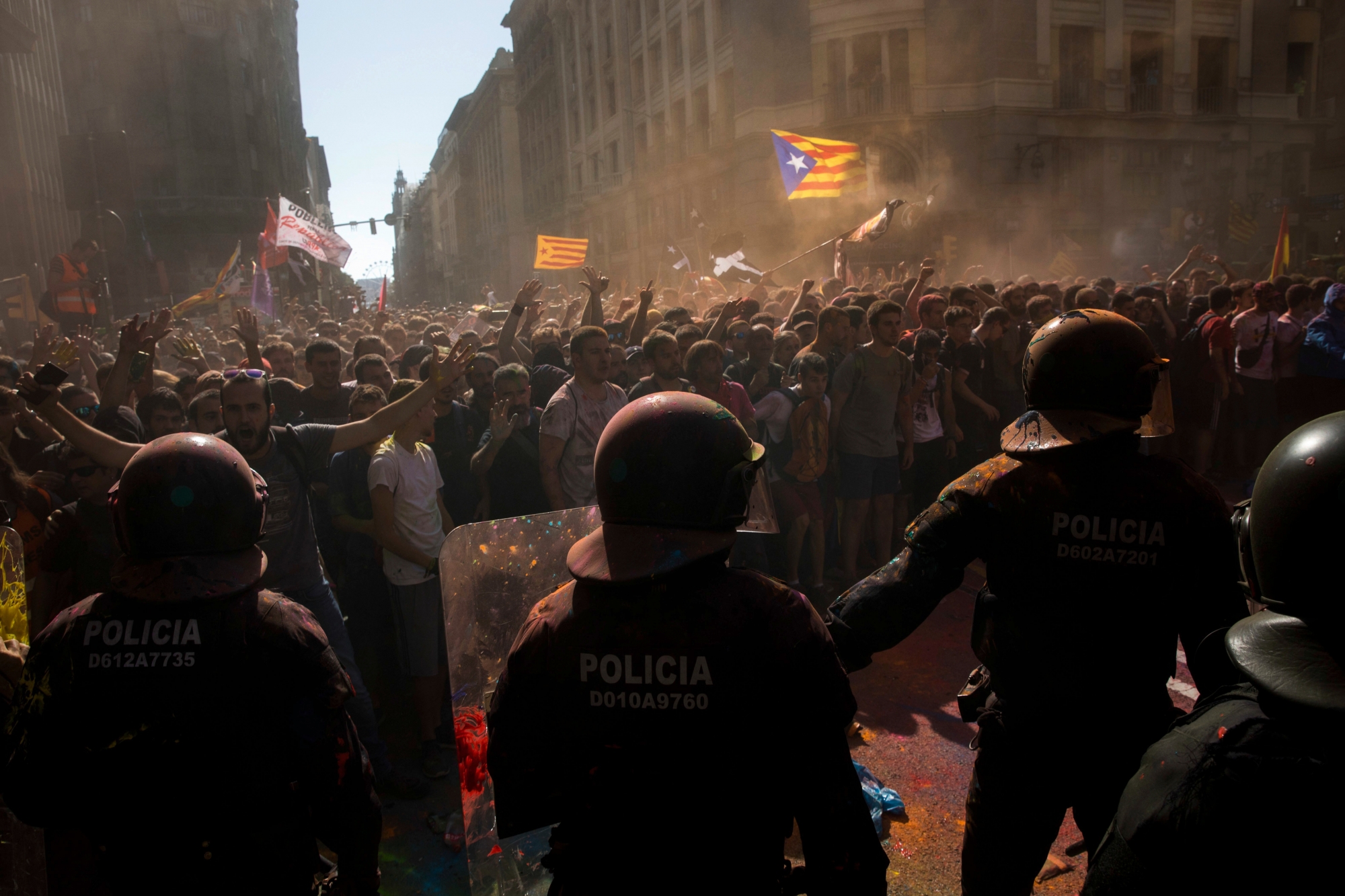 Catalan police officers cordon off the street to stop pro independence demonstrators on their way to meet demonstrations by members and supporters of National Police and Guardia Civil, as coloured powder is seen on the ground after being thrown by protesters, in Barcelona on Saturday, Sept. 29, 2018. (AP Photo/Emilio Morenatti) Spain Catalonia