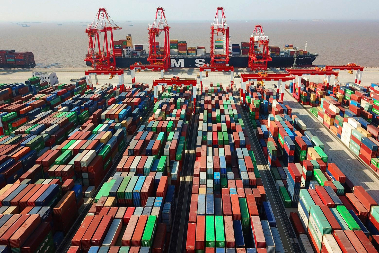 FILE - In this April 10, 2018, file photo, a cargo ship is docked at the Yangshan container port in Shanghai, China. The Asian Development Bank has slightly downgraded its growth forecasts in its latest outlook report for the region, citing the fallout from trade tensions, rising debt and the potential impact from tightening of credit in the U.S. (Chinatopix via AP, File) Asia Economy