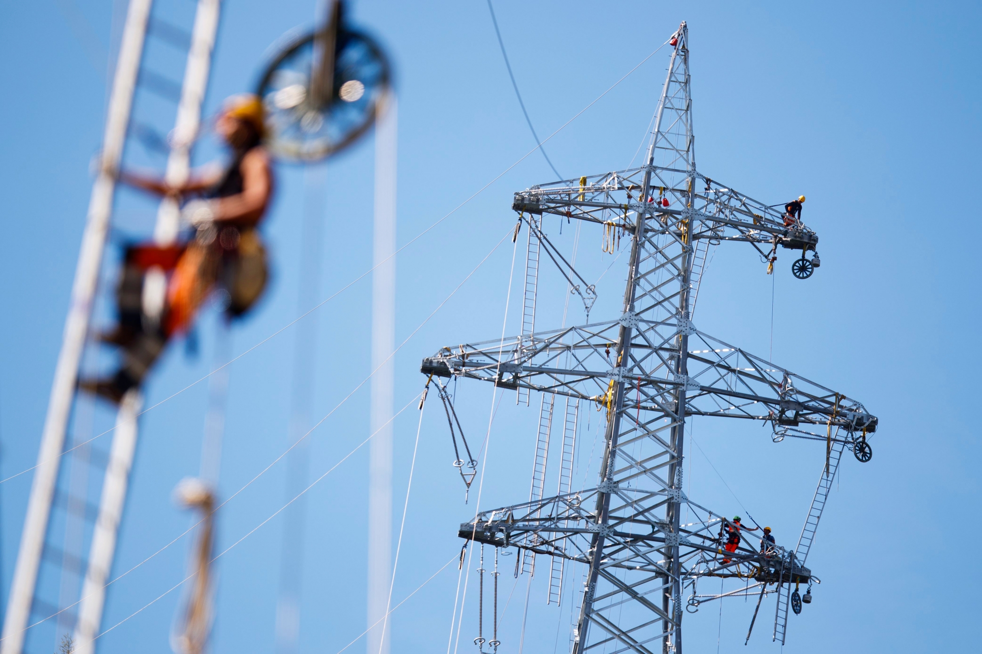 THEMENBILD ZUR MK VON BUNDESRAETIN LEUTHARD ZUR REVISION DES STROMVERSORGUNGSGESETZES, AM MITTWOCH, 17. OKTOBER 2018 ---- A staff members installs a rope prior to pulling the final electric power line cable during construction operations of a new Swissgrid 220 kV aerial electric line in the industrial zone of Chandoline in Sion, Switzerland, June 8, 2017. (KEYSTONE/Valentin Flauraud) SCHWEIZ MK BUNDESRAT