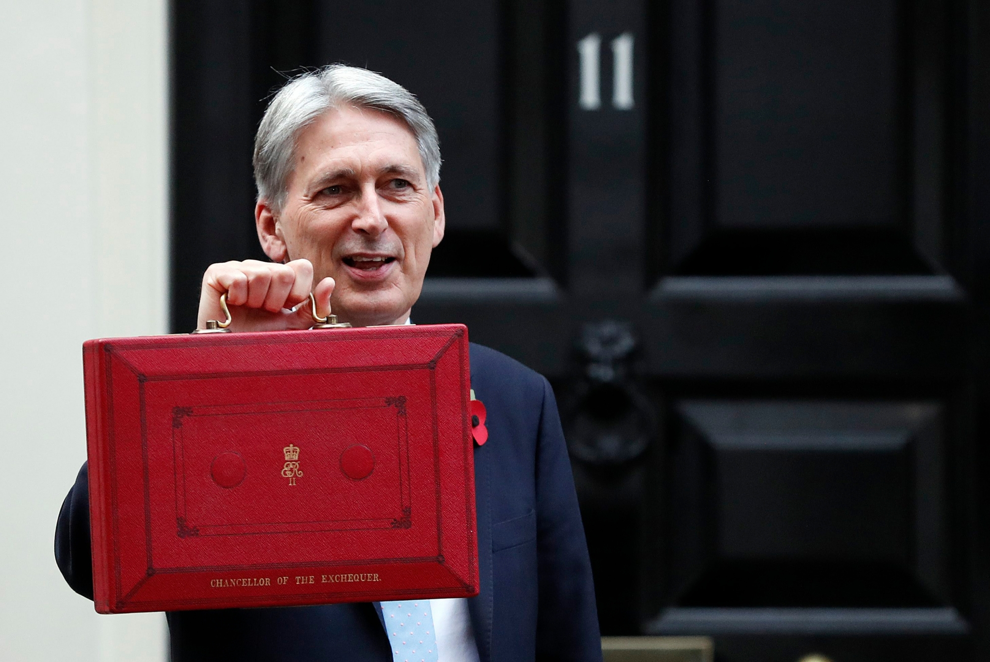 Britain's Chancellor of the Exchequer Philip Hammond poses for the media as he holds up the traditional red dispatch box, outside his official residence 11 Downing Street before delivering his annual budget speech to Parliament in London, Monday, Oct. 29, 2018.(AP Photo/Frank Augstein) Britain Budget