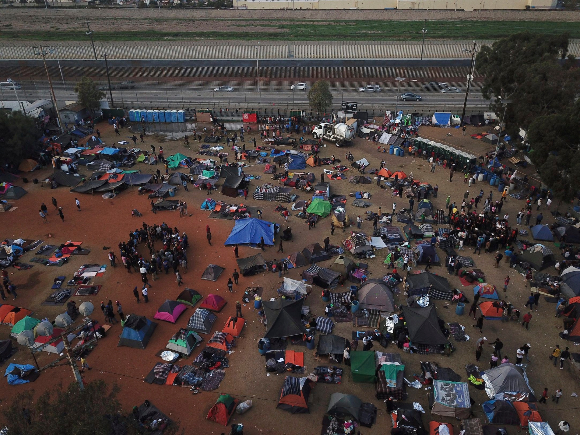 Central American migrants gather at a temporary shelter, near barriers that separate Mexico and the United States, in Tijuana, Mexico, Wednesday, Nov. 21, 2018. Migrants camped in Tijuana after traveling in a caravan to reach the U.S are weighing their options after a U.S. court blocked President Donald Trump's asylum ban for illegal border crossers. (AP Photo/Rodrigo Abd) Central America Migrant Caravan