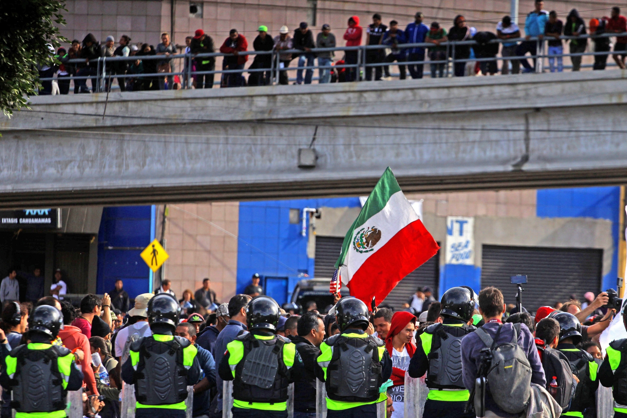 epa07183669 Mexican federal and municipal agents block Central American migrants, who marched from the shelter they occupy in Colonia Zona Norte, near the El Chaparral pedestrian gate in Tijuana, Mexico, 22 November 2018. Central American migrant caravan is making its way to the Mexico-USA border to request asylum after fleeing violence and poverty in other countries.  EPA/ALEJANDRO ZEPEDA CORRIGE FOTÓGRAFO MEXICO CARAVAN MIGRANTS