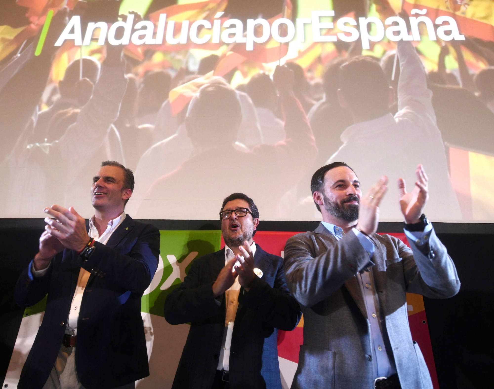epa07205021 General Secretary of right-wing party Vox, Javier Ortega (L), Andalusia presidential candidate Francisco Serrano (C) and Vox's President Santiago Abascal (R) wave supporters after the Andalusian regional election, in Sevilla, Spain, 02 December 2018. SpainÄôs far-right Vox party won 12 seats.  EPA/Rafa Alcaide SPAIN ANDALUSIA ELECTION
