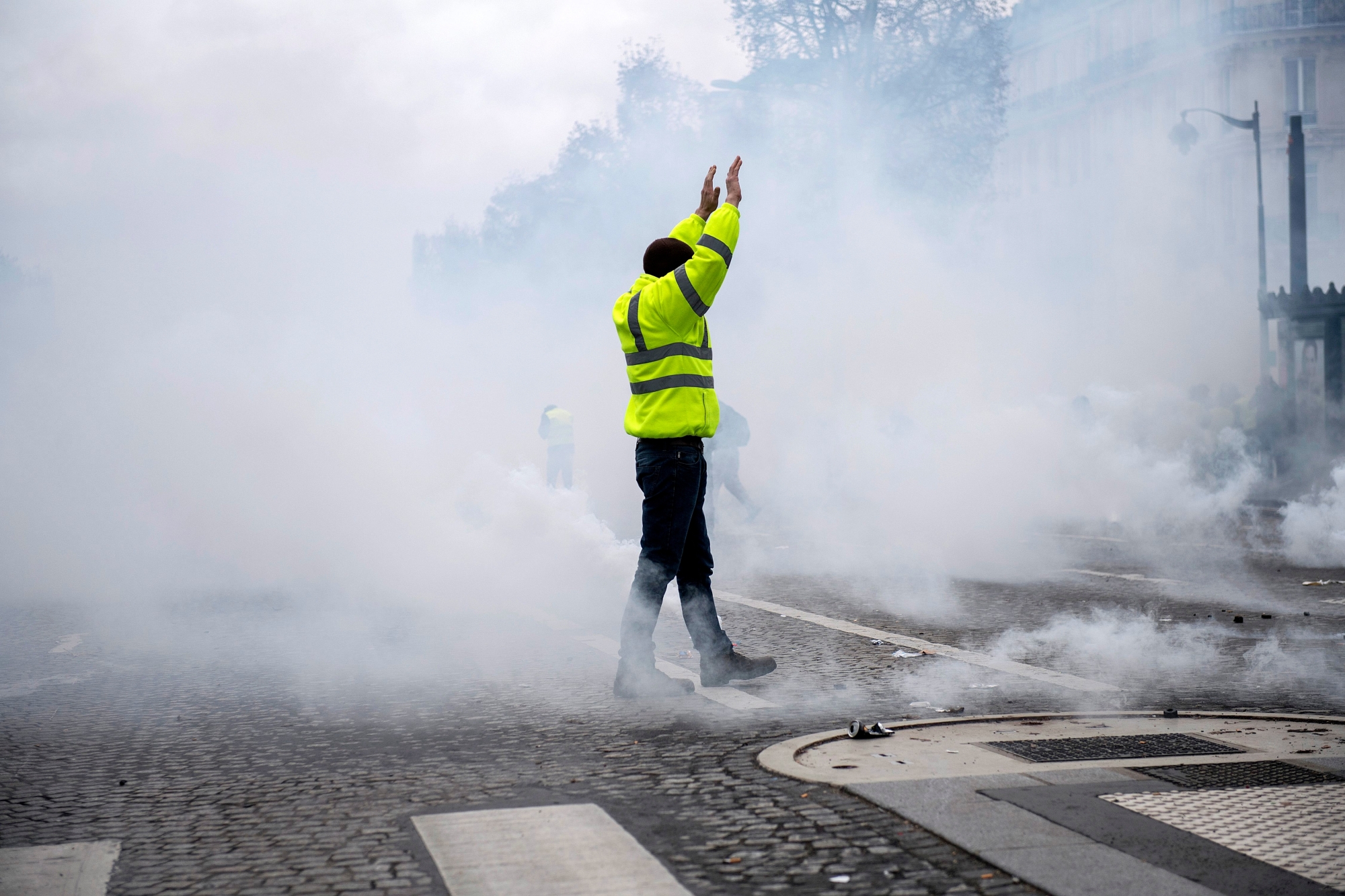 epaselect epa07216917 A yellow vest protester stands amid smoke during a demonstration in Paris, France, 08 December 2018. Police in Paris is preparing for another weekend of protests of the so-called 'gilets jaunes' (yellow vests) protest movement. Recent demonstrations of the movement, which reportedly has no political affiliation, had turned violent and caused authorities to close some landmark sites in Paris this weekend.  EPA/JULIEN DE ROSA epaselect FRANCE PROTEST YELLOW VESTS