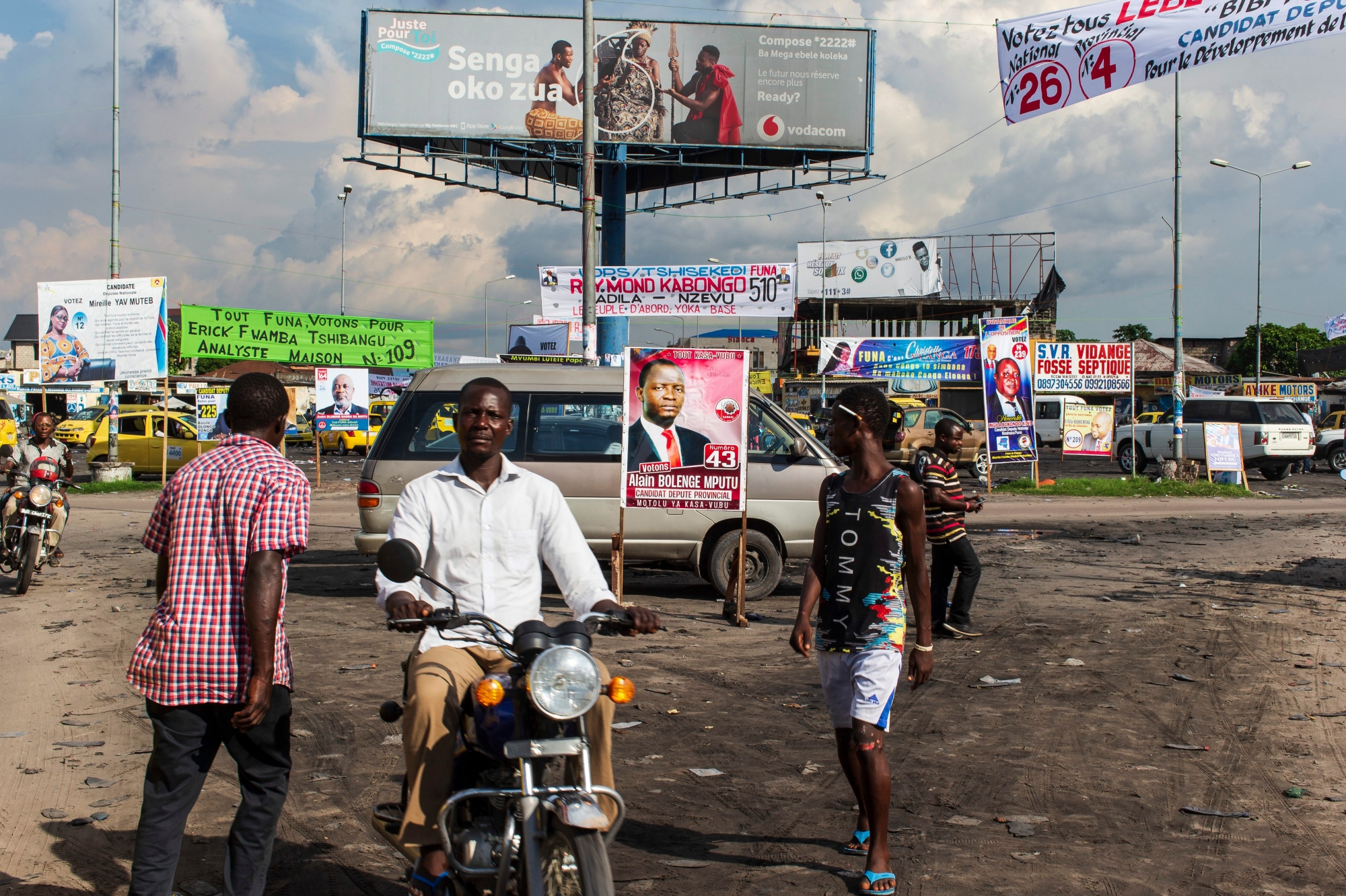 epa07242615 Election campaign posters are seen in a busy street in Kinshasa, Democratic Republic of Congo, 20 December 2018. The head of Congo's electoral commission Corneille Nangaa announced on 20 December that the poll, orignially scheduled for 23 December will be delayed by one week until 30 December, citing the recent fire that destroyed 80 percent of the voting machines. Emmanuel Ramazani Shadary, the ruling party candidate and a loyalist of outgoing president Joseph Kabila, faces challenges posed by Felix Tshisekedi, the leader of the Union for Democracy and Social Progress (UDPS) party, and the joint opposition candidate Martin Fayulu.  EPA/STEFAN KLEINOWITZ DR CONGO ELECTIONS