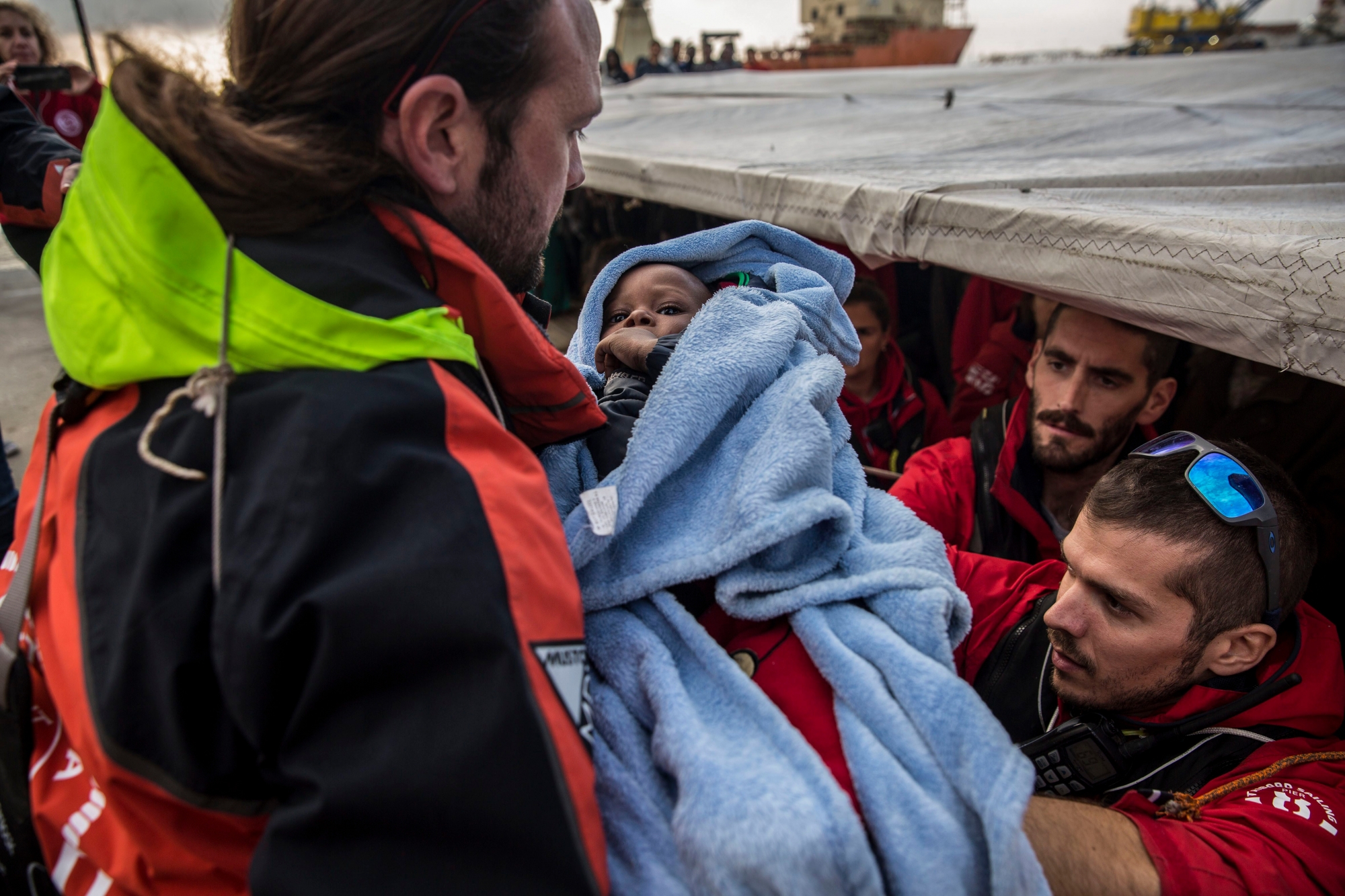 A migrant child is helped from the Spanish NGO Proactiva Open Arms rescue vessel, after being rescued Dec. 21, in the Central Mediterranean Sea, to disembark in the port of Crinavis in Algeciras, Spain, Friday, Dec. 28, 2018.  The Proactiva Open Arms aid boat carrying over 300 migrants rescued at sea, has ended a weeklong journey across the western Mediterranean Sea to dock at the Spanish port of Algeciras on Friday, after other European nations closed their ports to the ship. (AP Photo/Olmo Calvo) Spain Migration