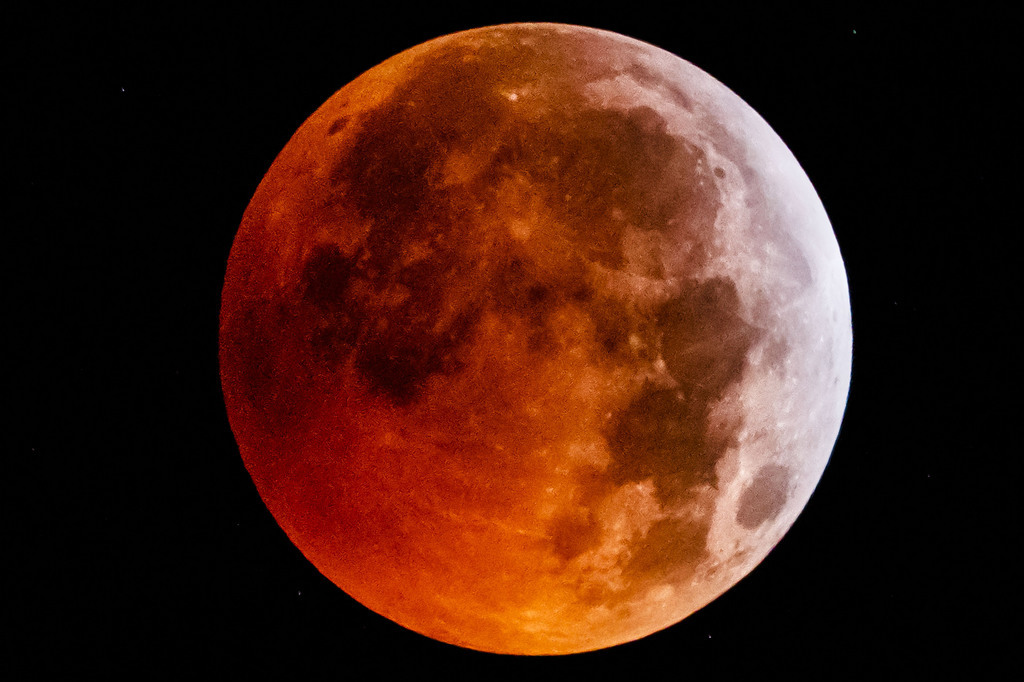 La lune rouge photographiée depuis Allaman, dans le canton de Vaud. Cette teinte rougeâtre est due au fait que les rayons du Soleil ne l'atteignent plus directement.