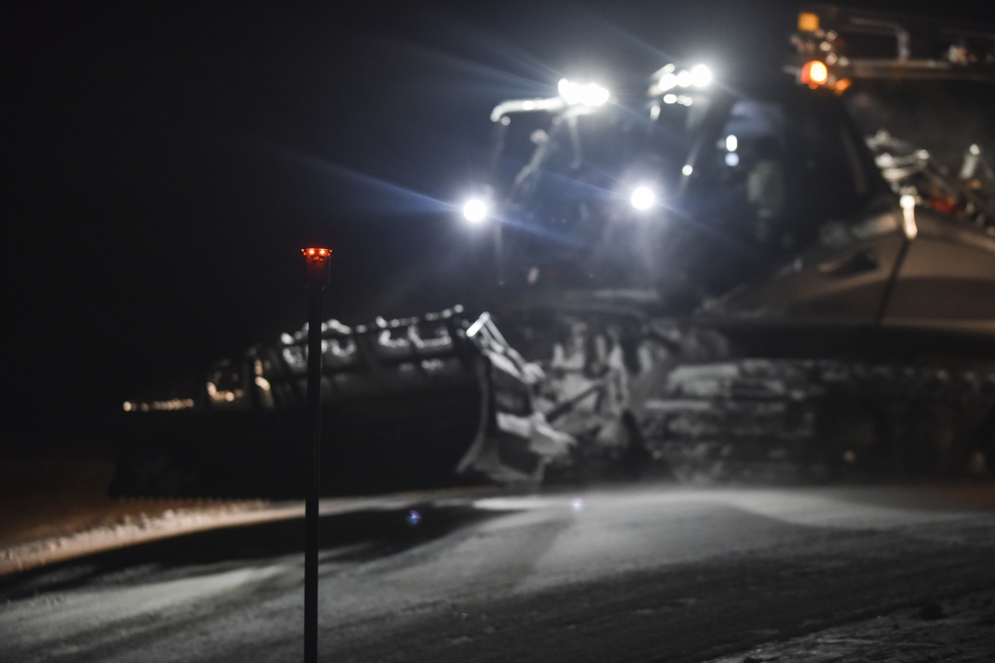 Des balises lumineuses s'allument et s'éteignent au passage de la dameuse.