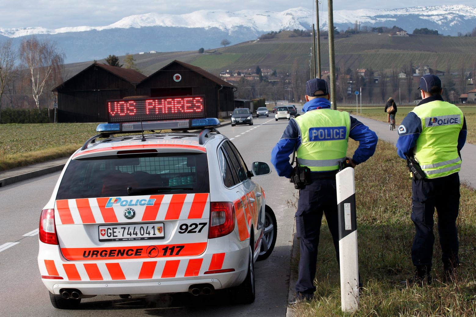 ZUR HERBSTSESSION AM MITTWOCH, 13. SEPTEMBER 2017, STELLEN WIR IHNEN FOLGENDES BILDMATERIAL ZUR VERFUEGUNG - Deux gendarmes de la police genevoise sensibilisent les automobilistes avec le message "Allumez vos phares" a l'aide d'une rampe lumineuse sur une route genevoise, ce lundi 6 janvier 2014 a Geneve. Une modification de la loi sur la circulation routiere est entre en vigueur le 1er janvier 2014 dans le cadre du programme federal Via Sicura: tous les automobilistes roulant en Suisse, que ce soit sur une voiture, un camion ou un deux-roues, devront rouler de jour avec les feux de croisement allumes. (KEYSTONE/Salvatore Di Nolfi) SCHWEIZ HERBSTSESSION