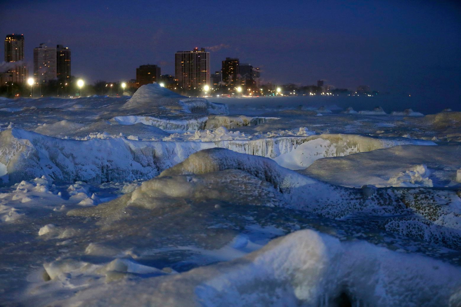 Ice forms along the shore of Lake Michigan before sunrise, Wednesday, Jan. 30, 2019, in Chicago. A deadly arctic deep freeze enveloped the Midwest with record-breaking temperatures on Wednesday, triggering widespread closures of schools and businesses, and prompting the U.S. Postal Service to take the rare step of suspending mail delivery to a wide swath of the region. (AP Photo/Kiichiro Sato) Winter Weather