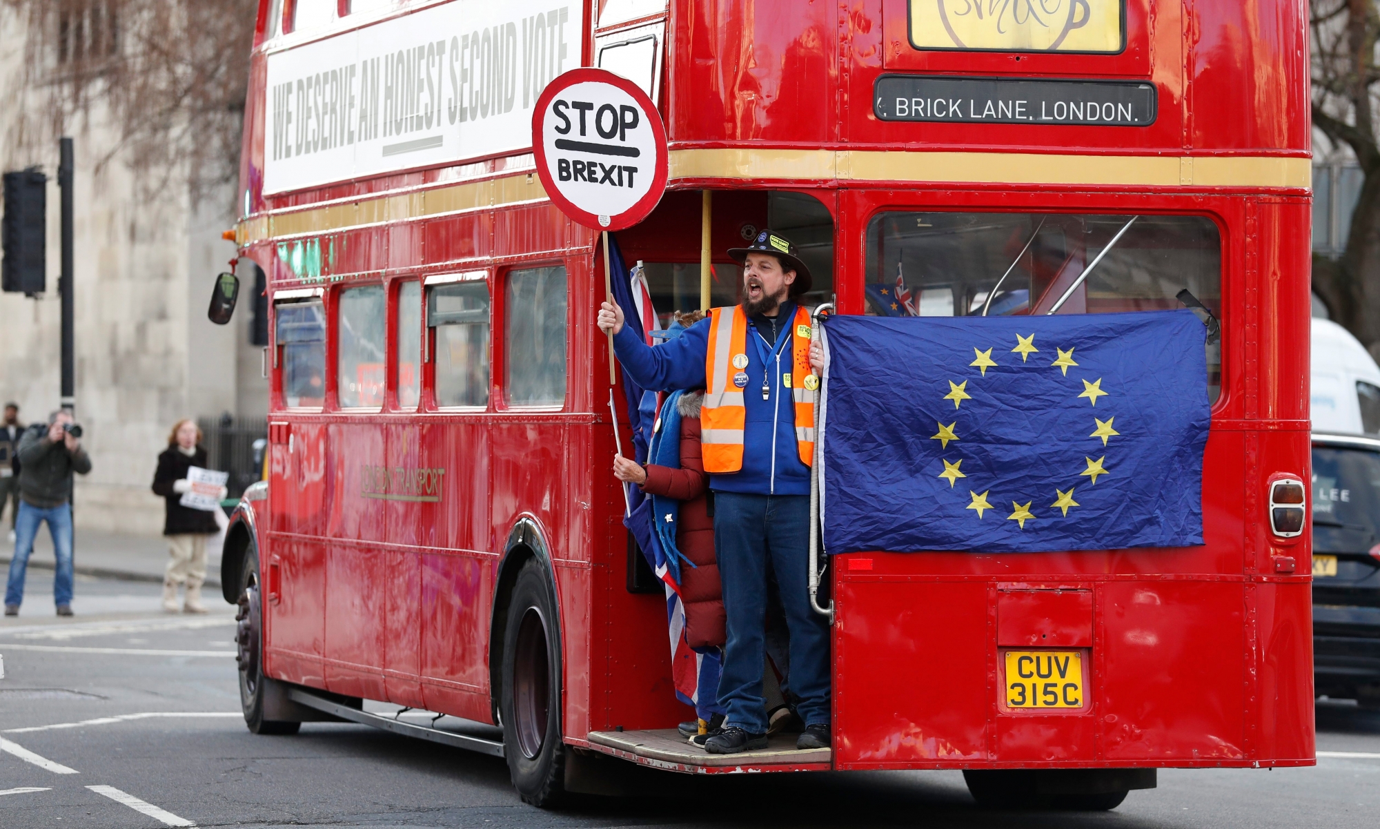 Anti Brexit protesters on board a hired red London bus demonstrate as they drive past the Houses of Parliament in London, Monday, Jan. 28, 2019. Pro-Brexit British lawmakers were mounting a campaign Monday to rescue May's rejected European Union divorce deal in a parliamentary showdown this week. (AP Photo/Alastair Grant) Britain Brexit