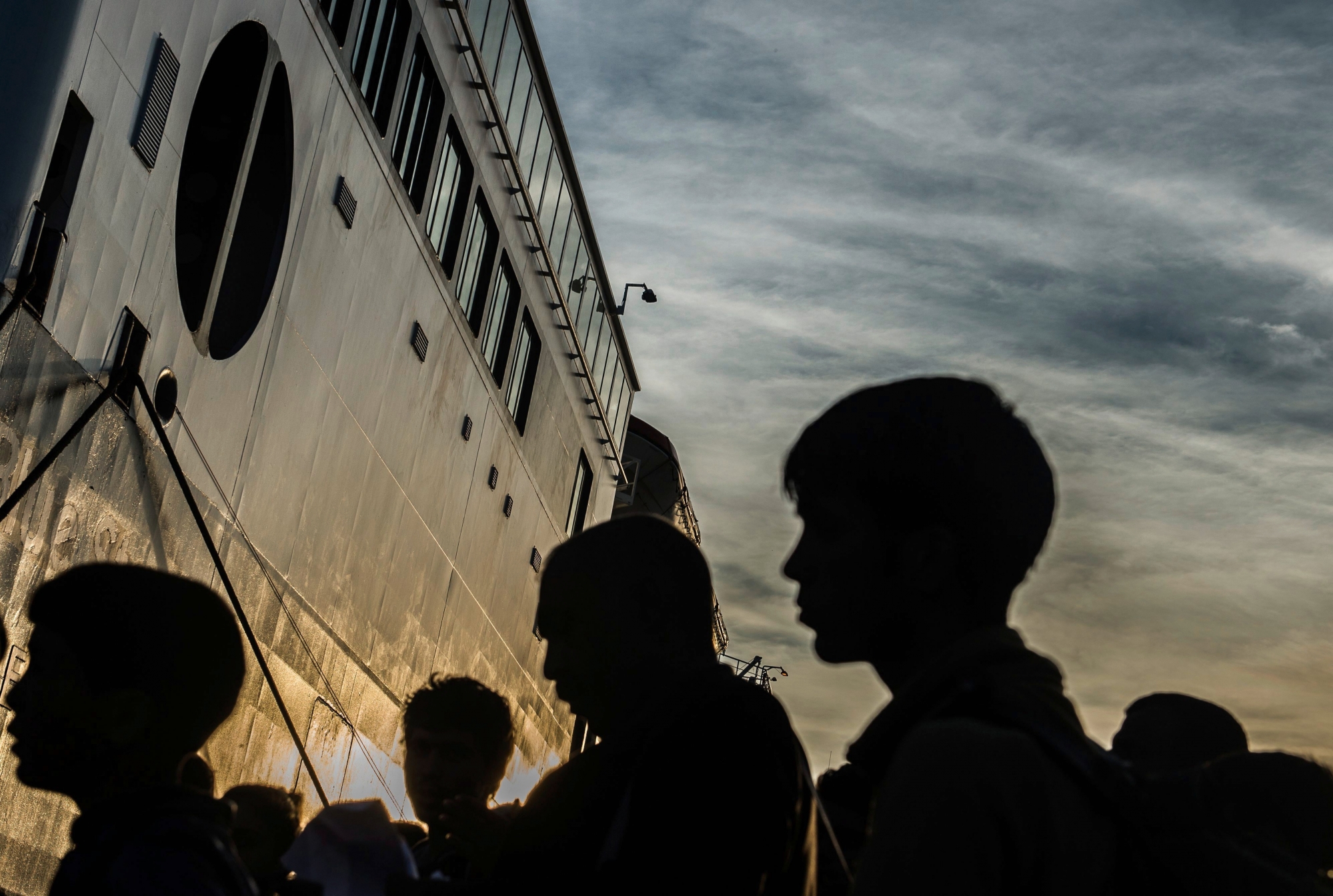 epa04964937 Refugees and migrants line up to board a ferry at the port in Mytilini, Lesbos island, Greece, 05 October 2015. The ferry will be carrying more two thausands refugees and migrants that had landed on the Greek island of Lesvos in past days, crossing from Turkey. An estimated 100,000 refugees and migrants arrived on the Greek islands during August, according to the Hellenic Coast Guard.  EPA/FILIP SINGER GREECE MIGRATION REFUGEES CRISIS