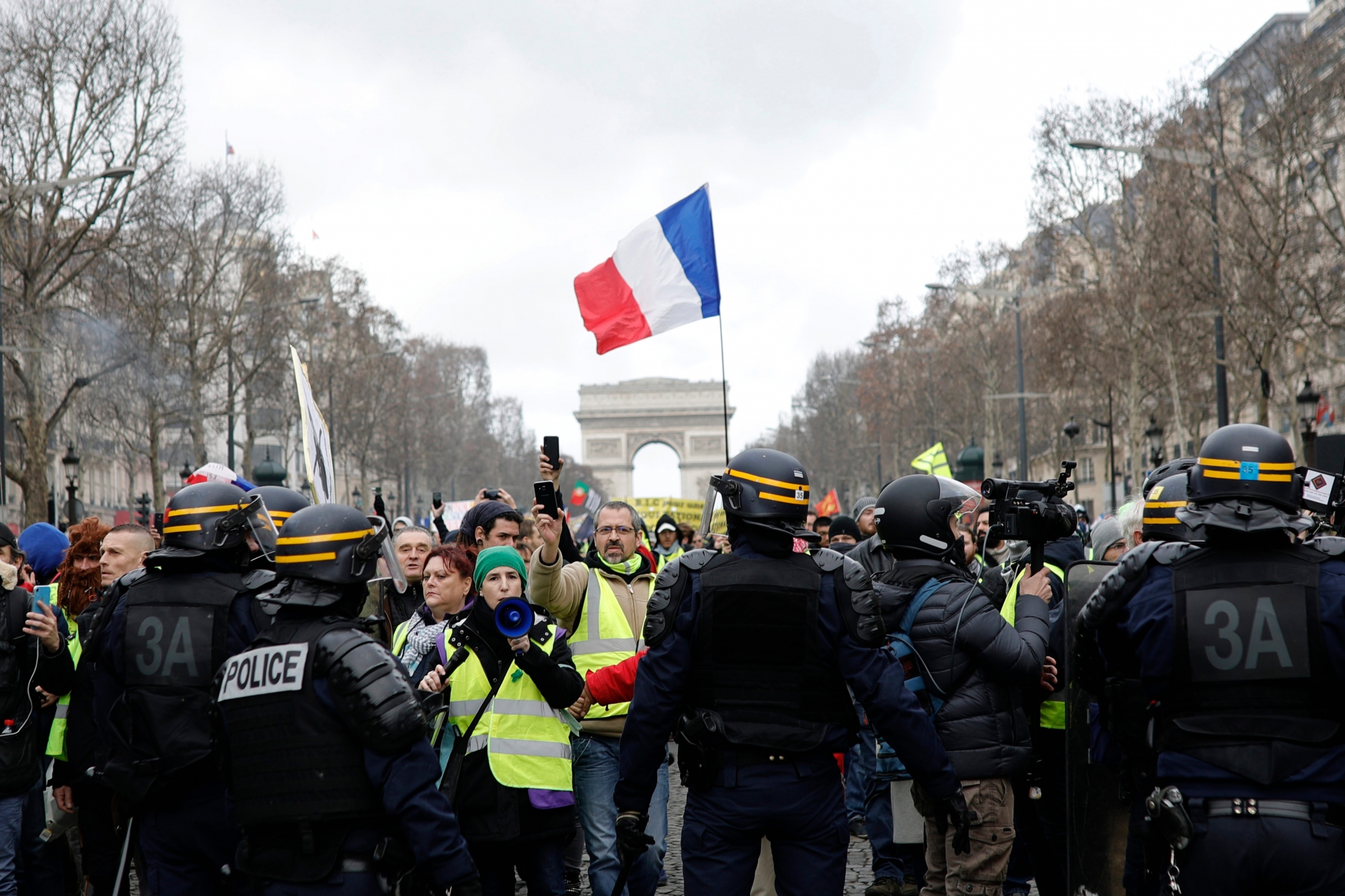 Yellow vest protesters walk down the famed Champs Elysees avenue to keep pressure on French President Emmanuel Macron's government, for the 13th straight weekend of demonstrations, in Paris, France, Saturday, Feb. 9, 2019. (AP Photo/Kamil Zihnioglu) France Protests