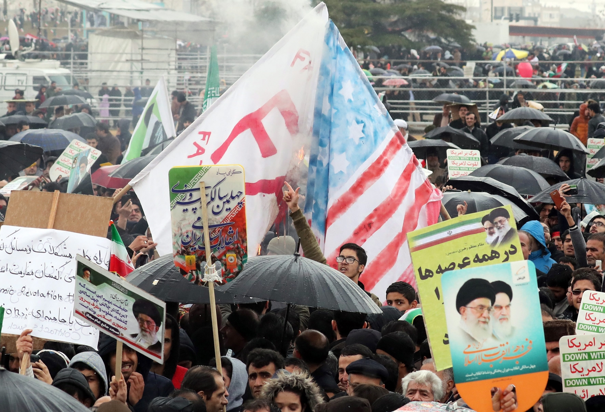 epa07361559 Iranians burn a mock US flag during a ceremony marking the 40th anniversary of the 1979 Islamic Revolution, at the Azadi (Freedom) square in Tehran, Iran, 11 February 2019. The event marks the 40th anniversary of the Islamic revolution, which came ten days after Ayatollah Ruhollah Khomeini's return from his exile in Paris to Iran, toppling the monarchy system and forming the Islamic Republic.  EPA/ABEDIN TAHERKENAREH IRAN ISLAMIC REVOLUTION ANNIVERSARY