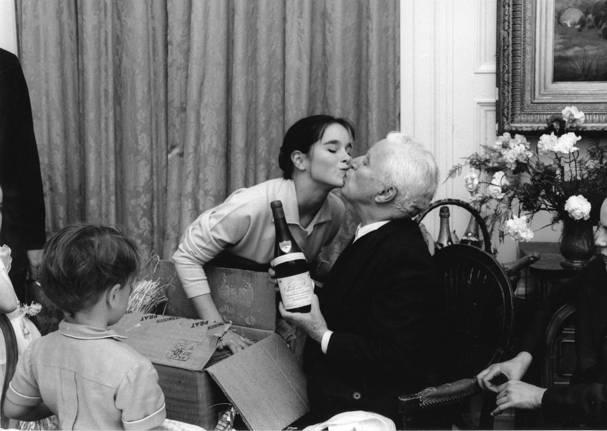 Charlie Chaplin embrassé par sa fille Géraldine à l'occasion de ses 70 ans célébrés au Manoir de Ban le 16 avril 1959.