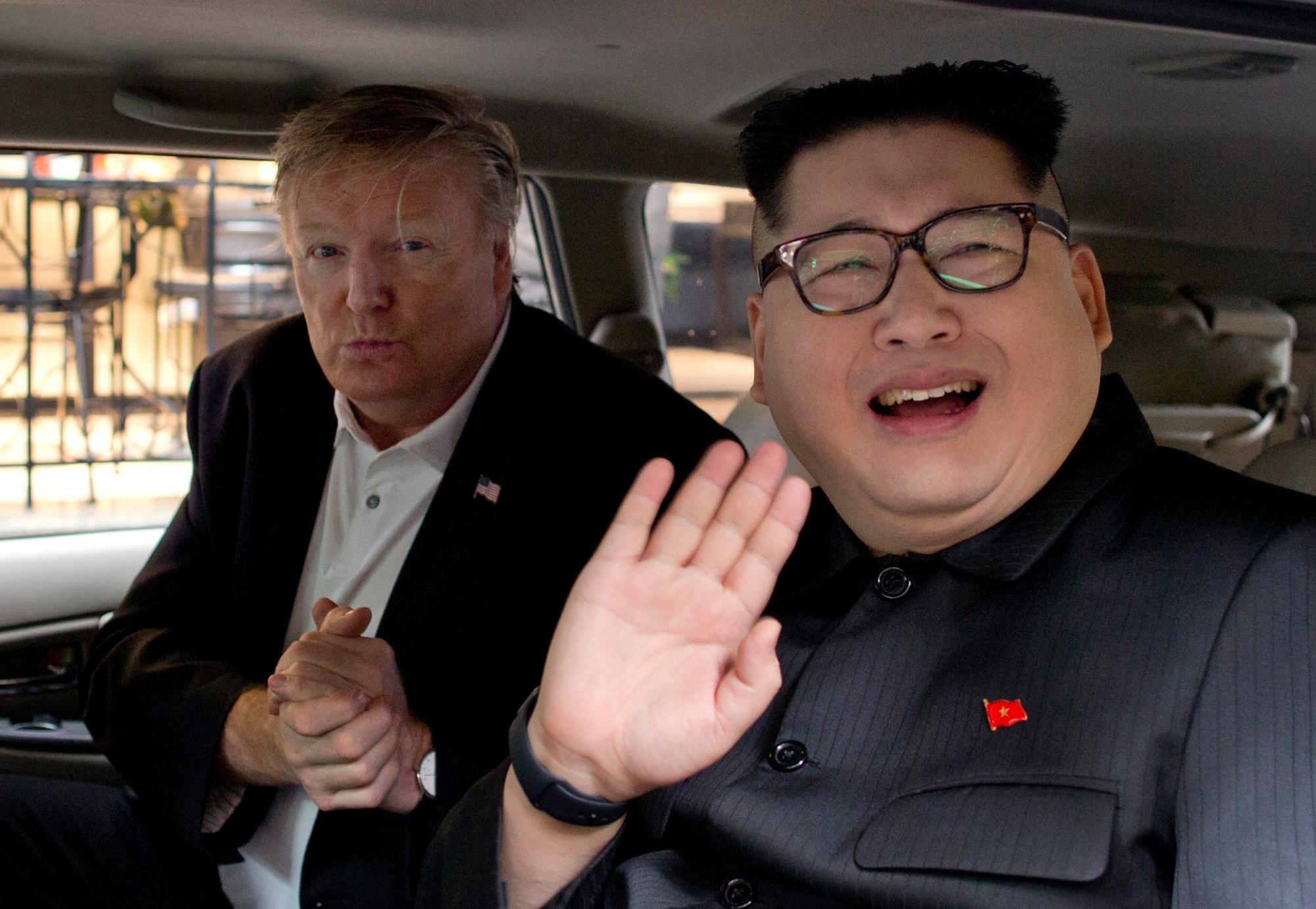 Howard X, right, an Australian impersonating North Korean leader Kim Jong Un, waves as Russel White, a U.S. President Donald Trump impersonator, gestures from a car outside La Paix hotel in Hanoi, Vietnam, Monday, Feb. 25, 2019. Take the reaction to the two impersonators who'd been posing for pictures with curious onlookers ahead of the second U.S.-North Korean summit. (AP Photo/Gemunu Amarasinghe) Trump Kim Summit